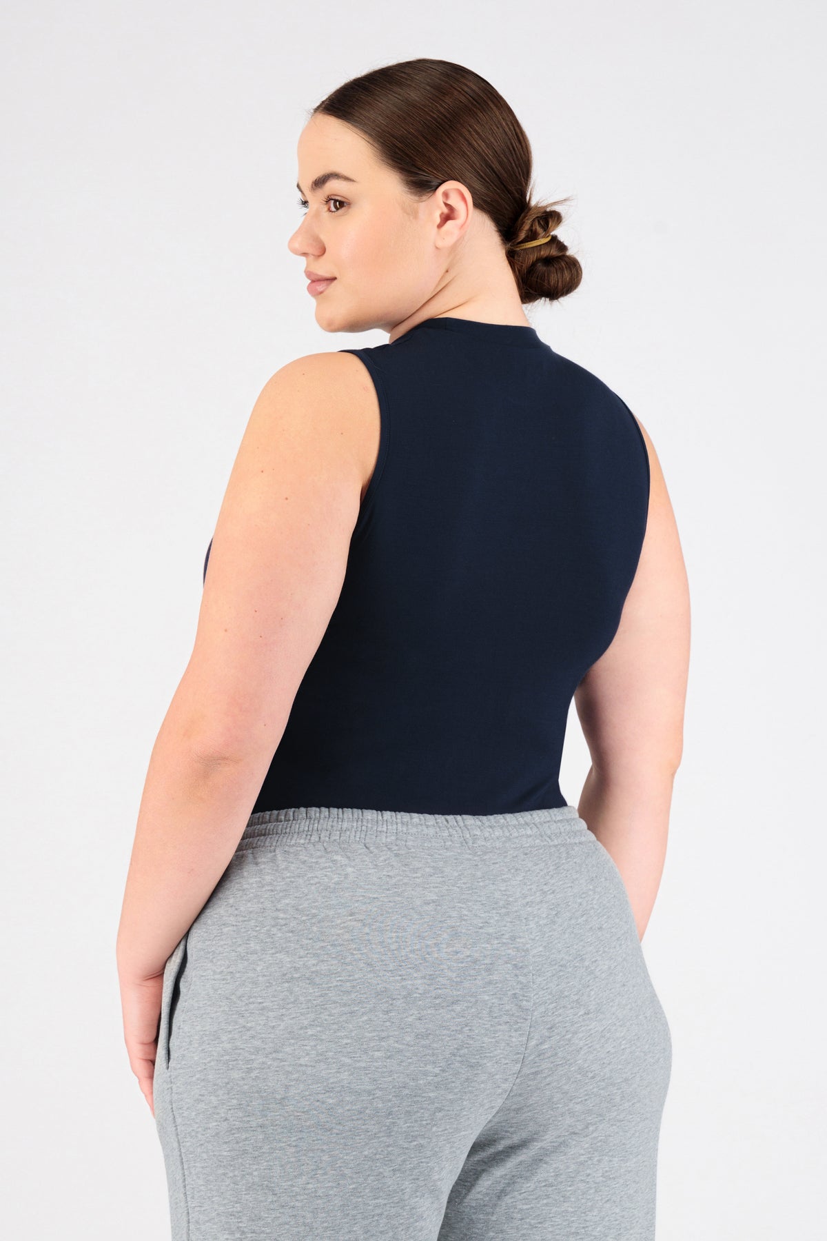 A girl wearing FARES' sleeveless layer is shown from the back while looking over her left shoulder. Colour description: Navy.