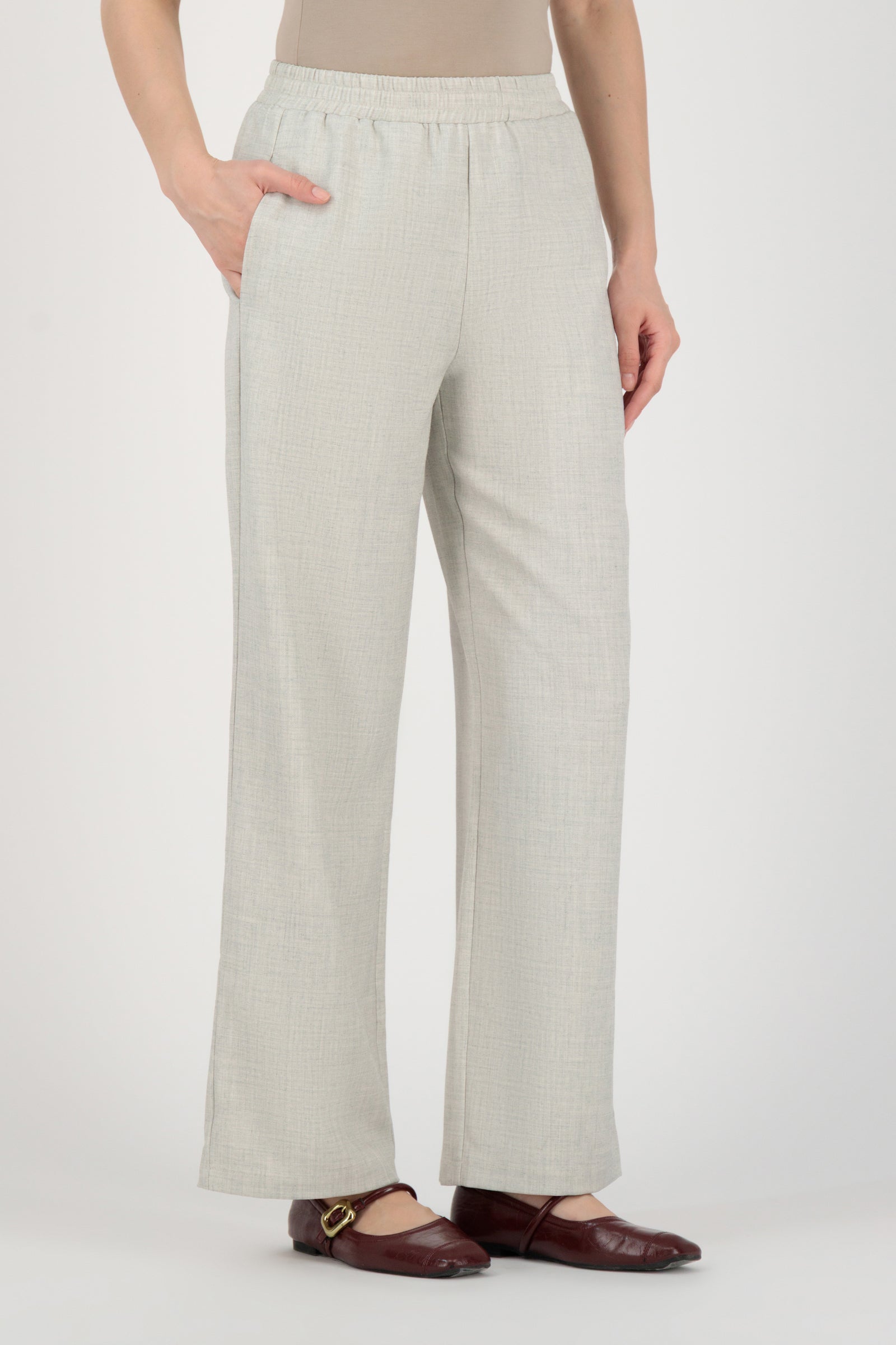 Angled back view of the FARES Tailored Elastic Waist Pants in Chalk showing effortless drape and the tailored proportions of these wide leg pants.