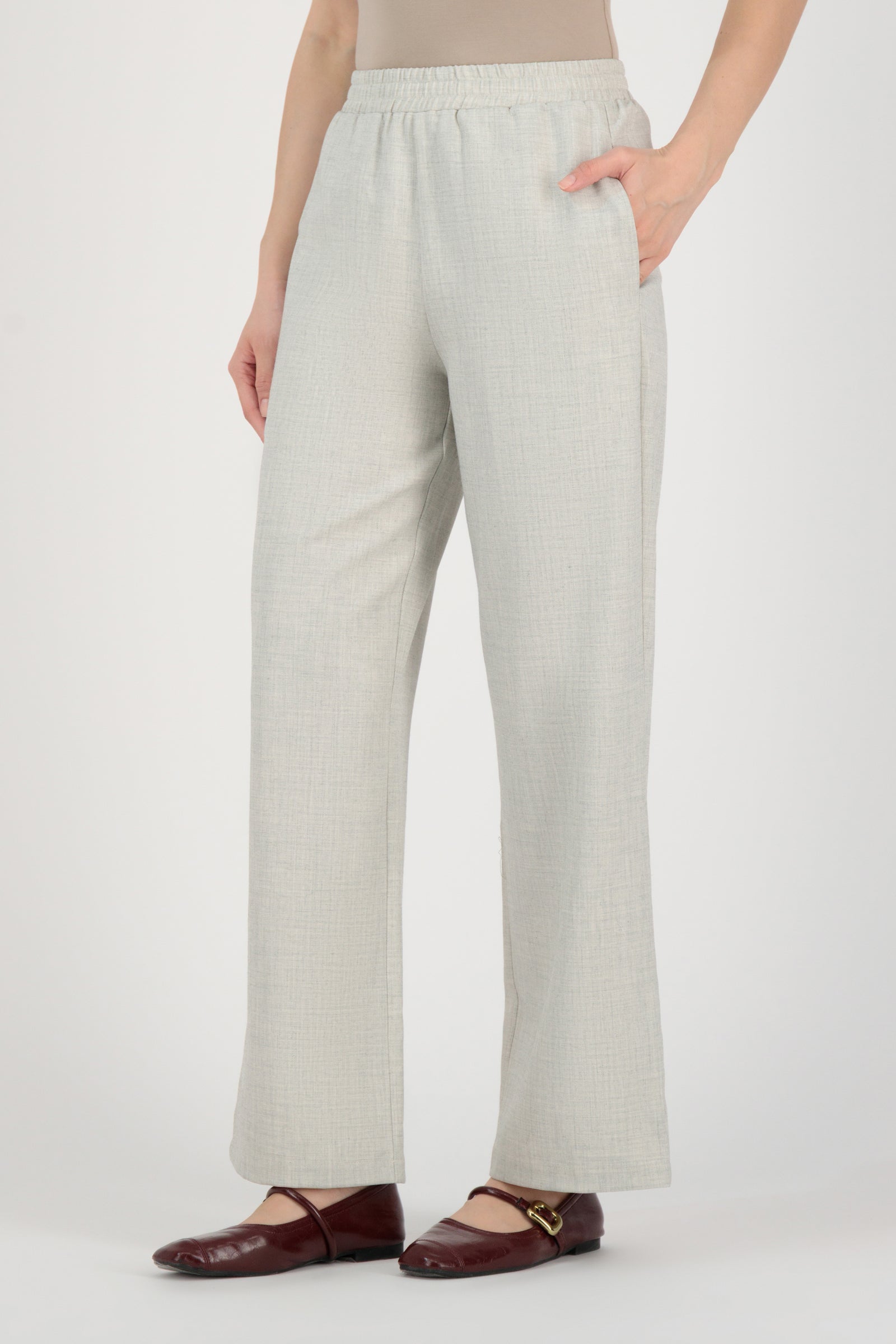 Side angle of the FARES Tailored Elastic Waist Pants in Chalk emphasizing fluid wide leg pants movement with a refined elastic waistband.