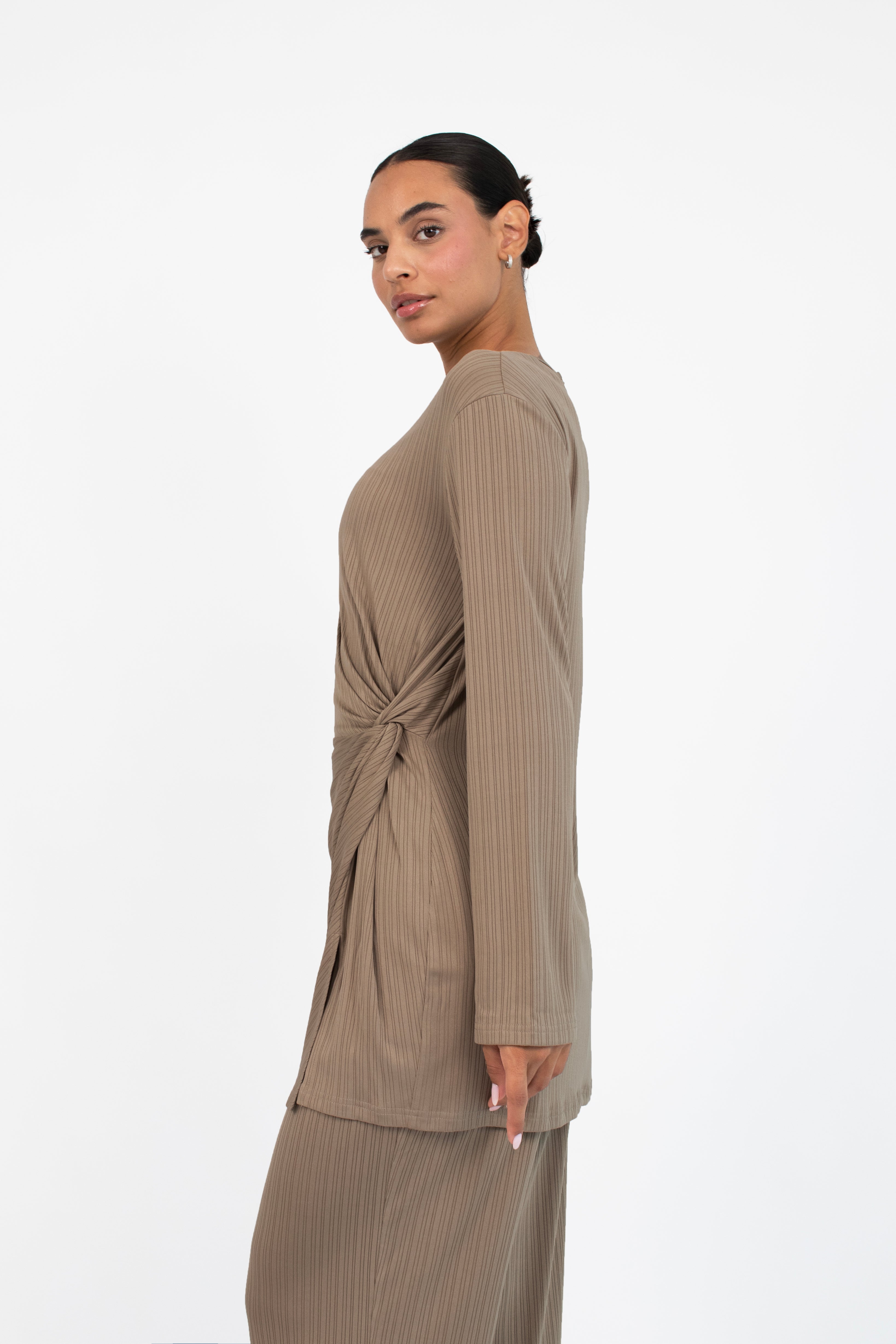 Colour: Taupe. A woman turned left wearing a Ribbed Side Twist Top.