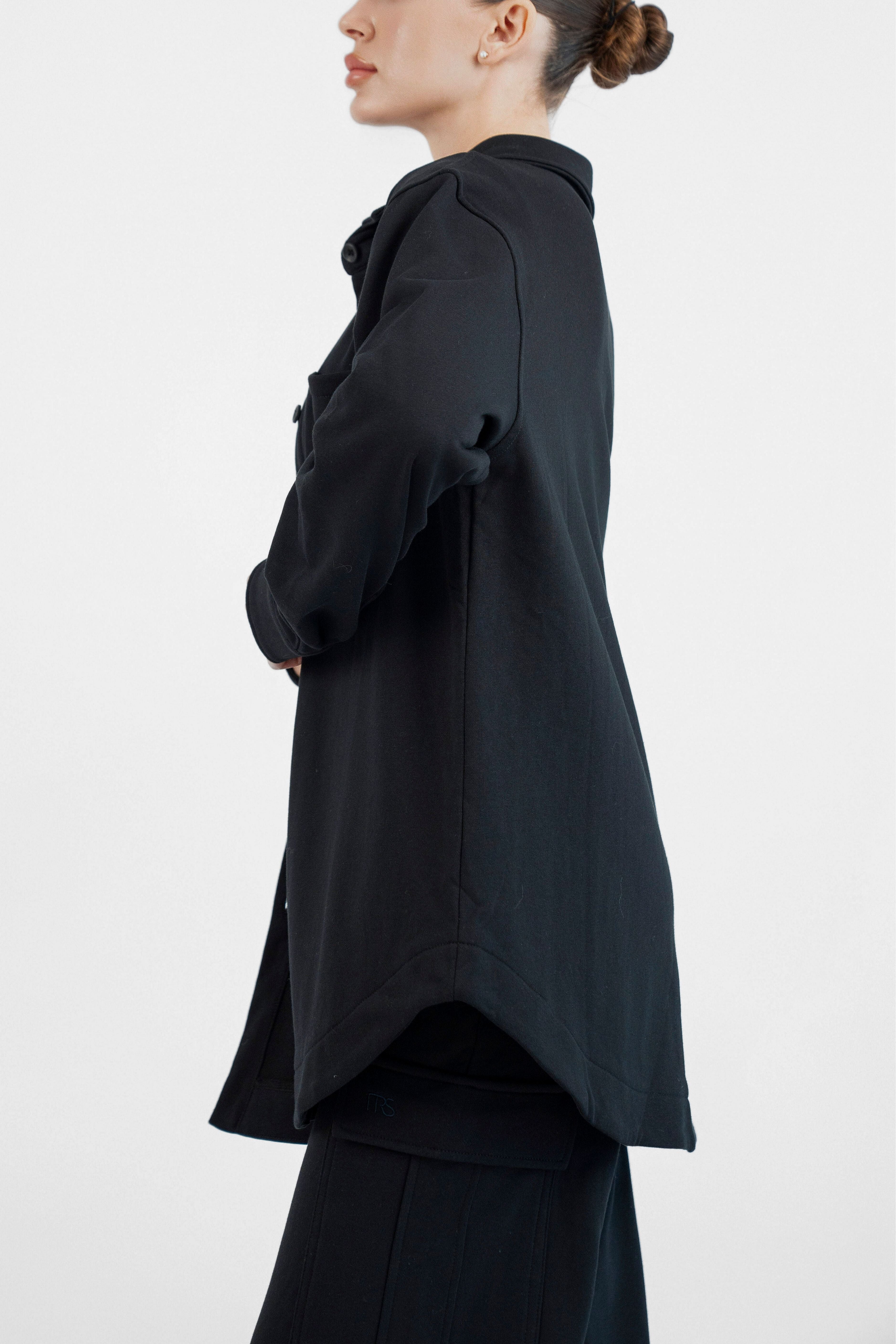 Colour: Black. A girl is turned to the left in an Oversized Cotton Shacket.