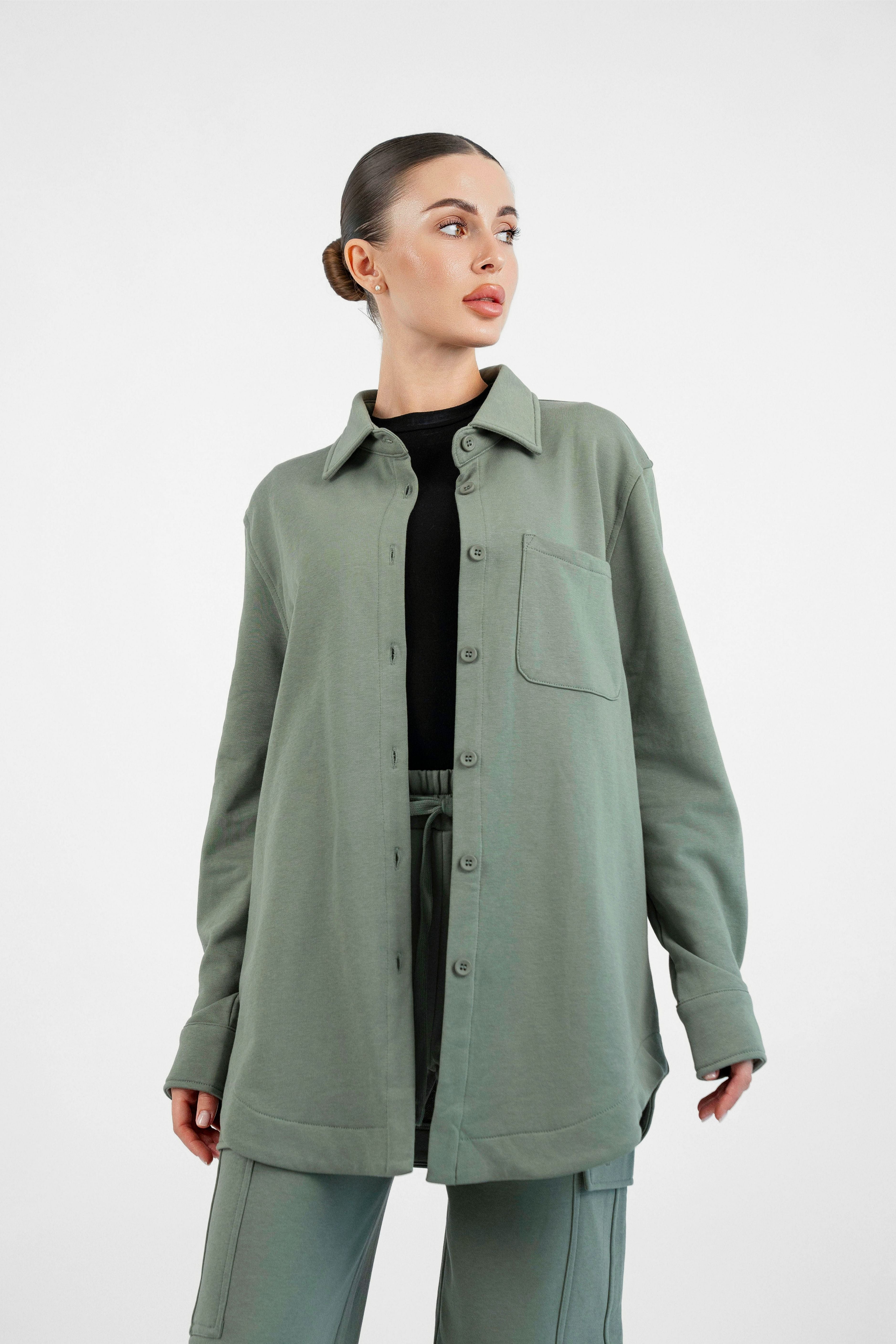 Colour: Oakmoss. A girl is looking to the right wearing an Oversized Cotton Shacket.