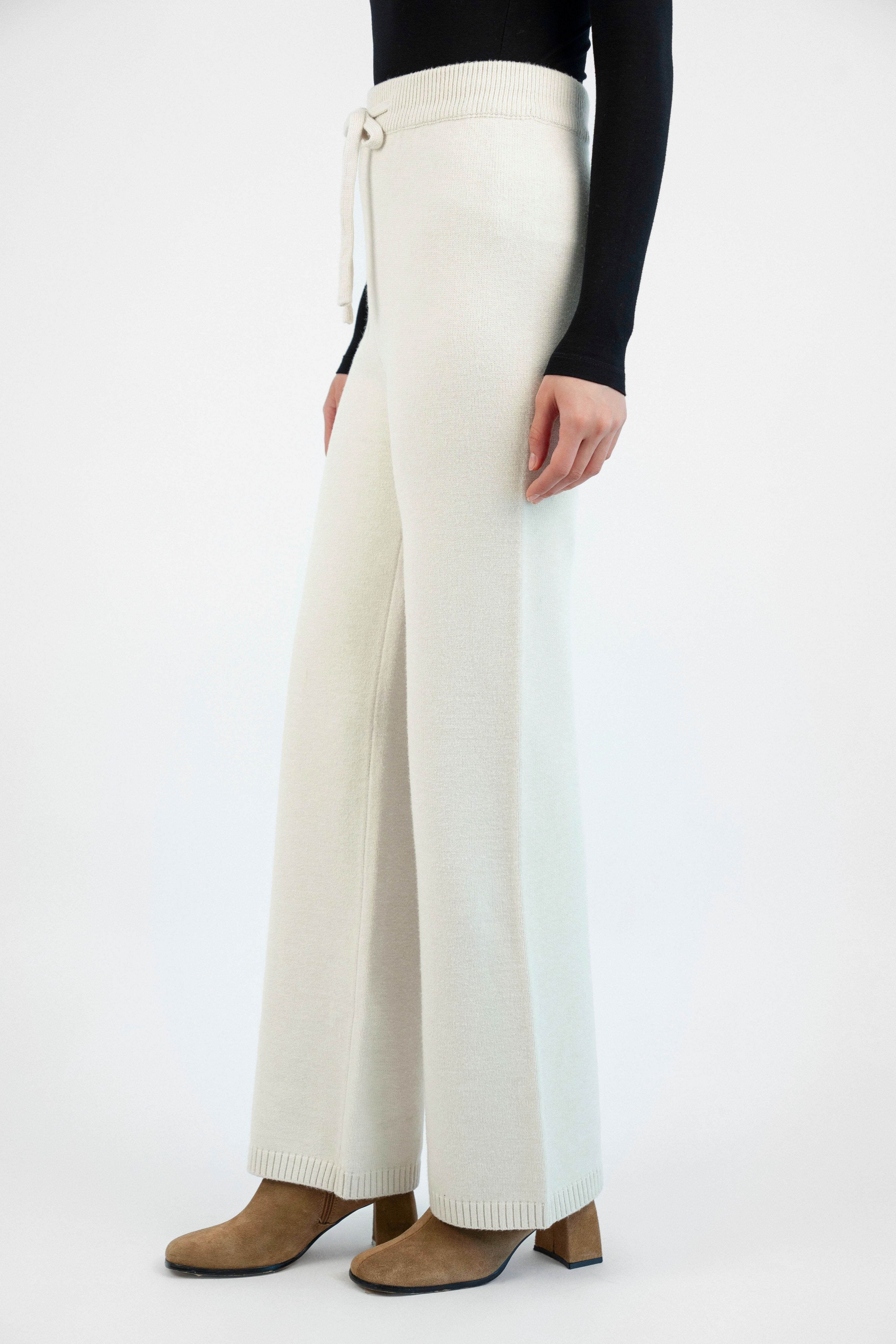 Side view of the Cloud Knit Pants in Cream, highlighting the fluid drape and airy knit fabric for a modern, comfortable fit.