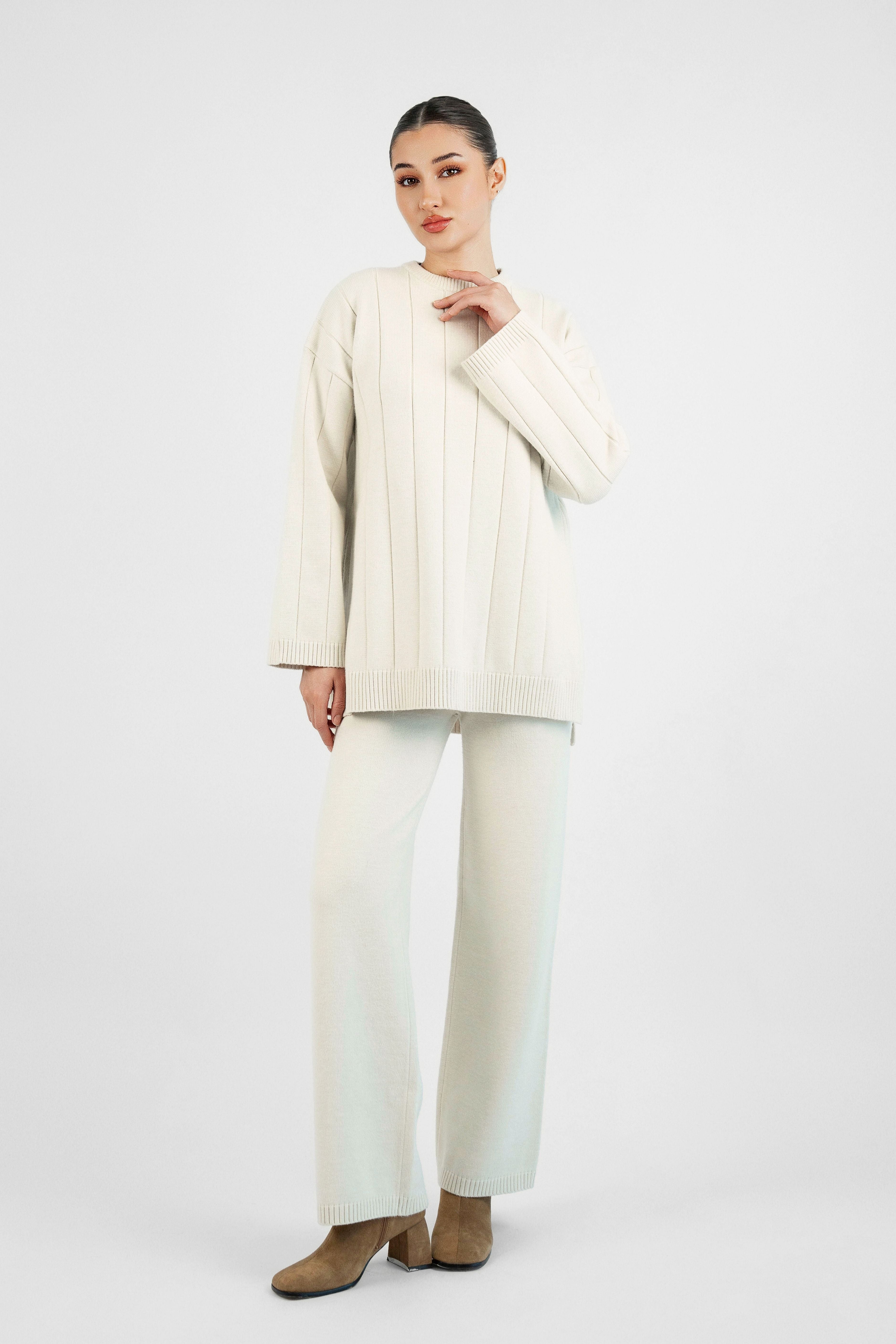 Colour: Cream. A girl in a pose with her hand on her neck wearing a Cloud Knit Sweater