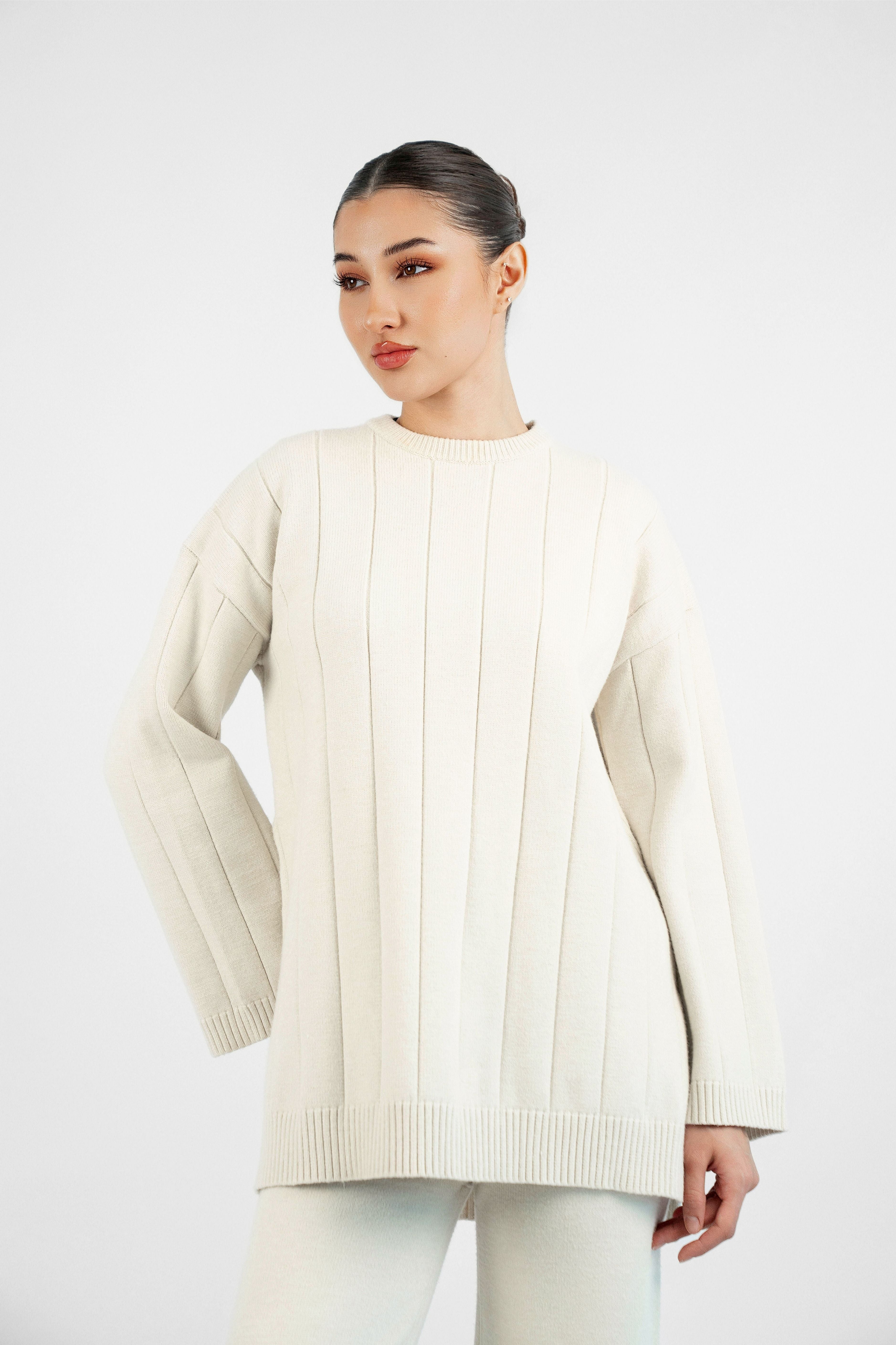 Colour: Cream. A closer look of a girl in a front pose wearing a Cloud Knit Sweater