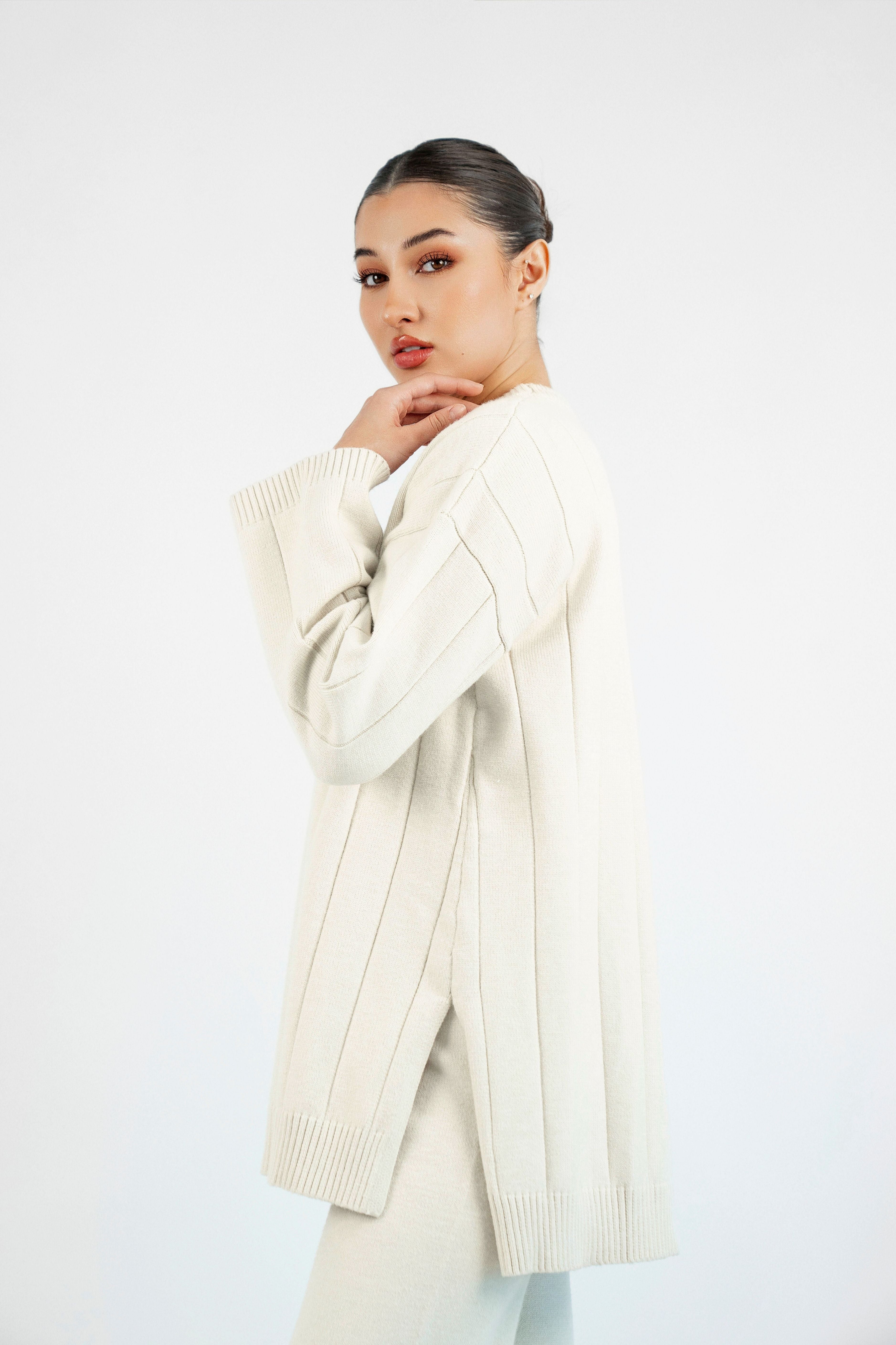 Colour: Cream. A side pose of a girl in a Cloud Knit Sweater