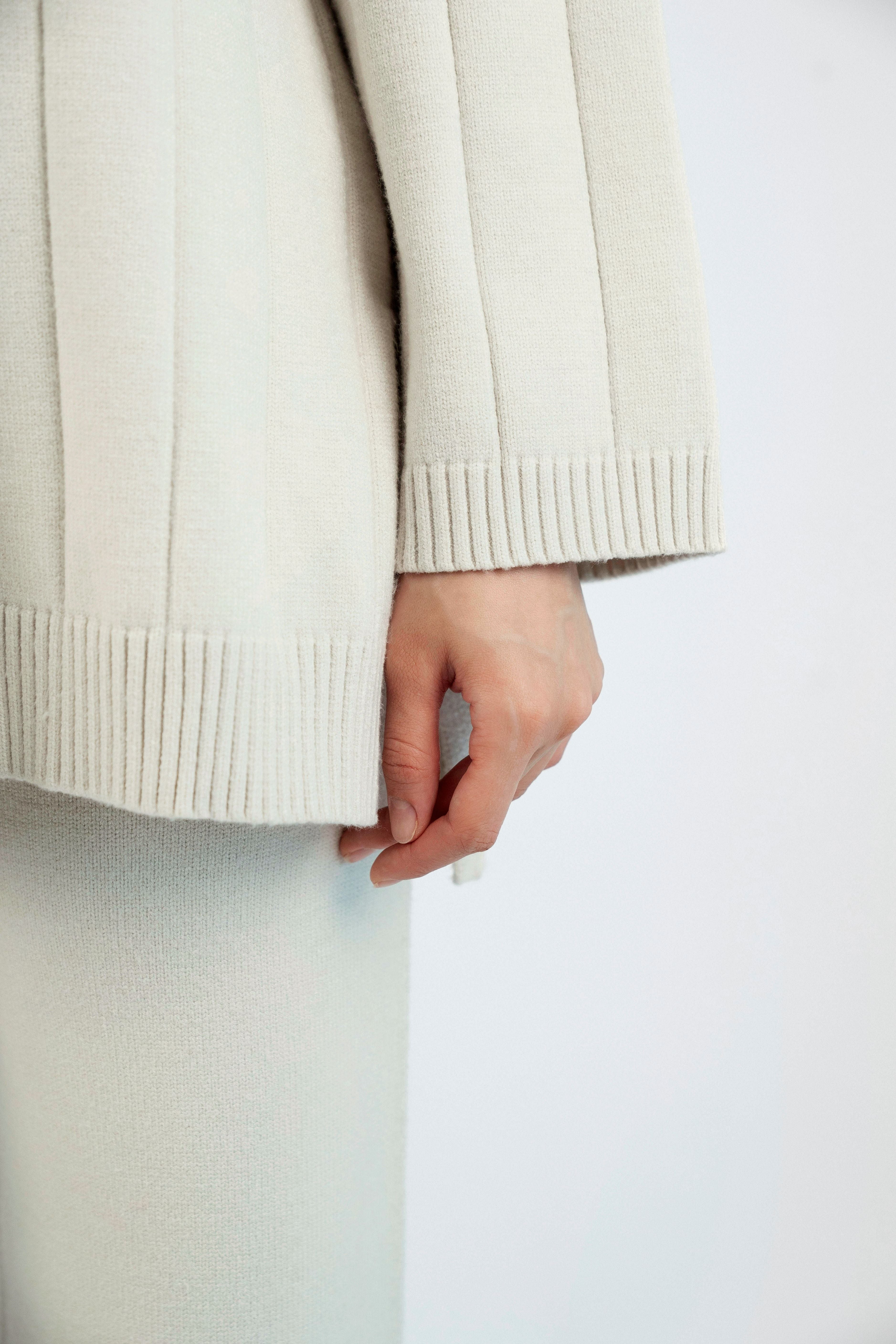 Colour: Cream. A close up of the sleeve of a Cloud Knit Sweater