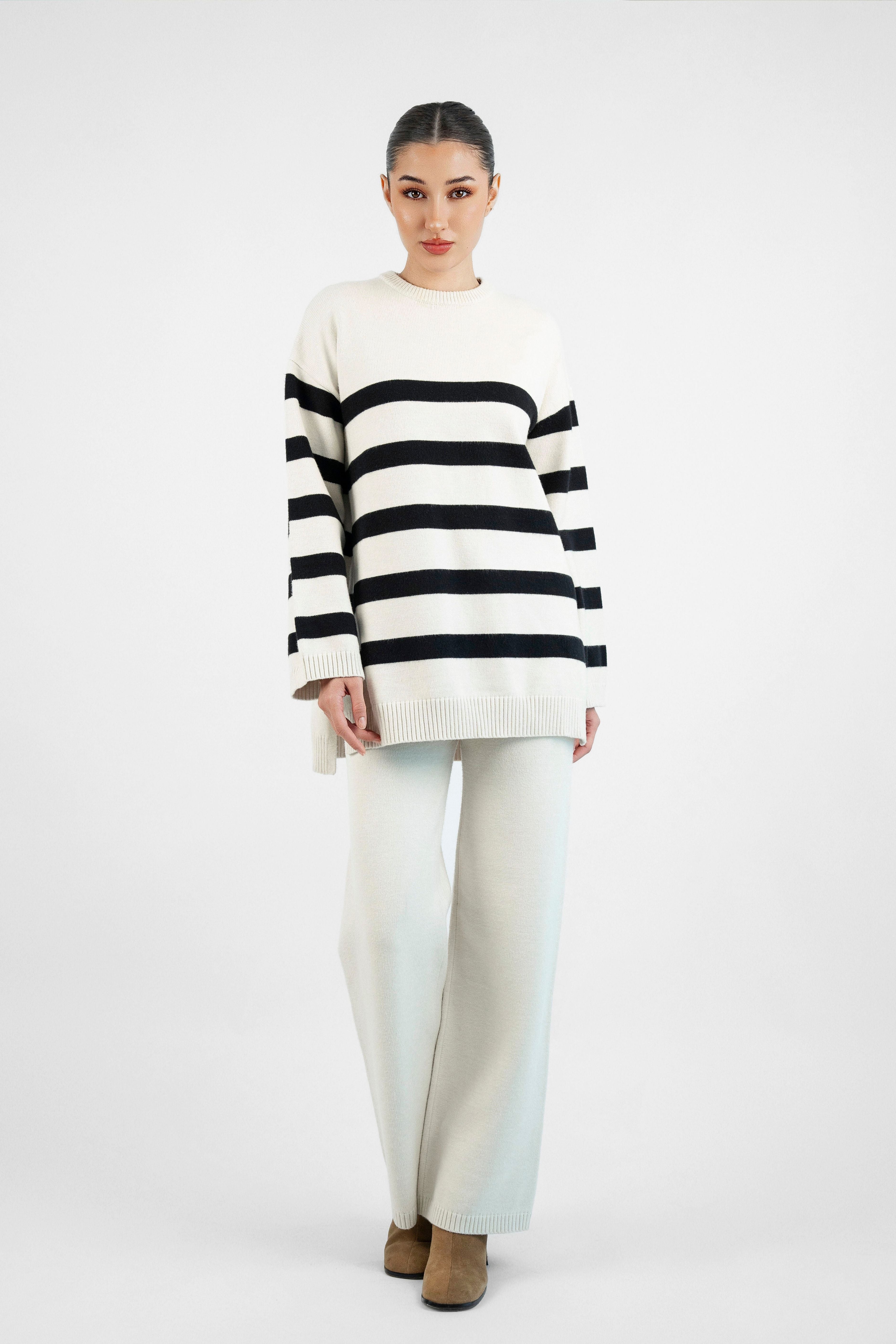 Model wearing the Cloud Knit Pants in Cream, styled with a matching top for an effortlessly chic and relaxed look.