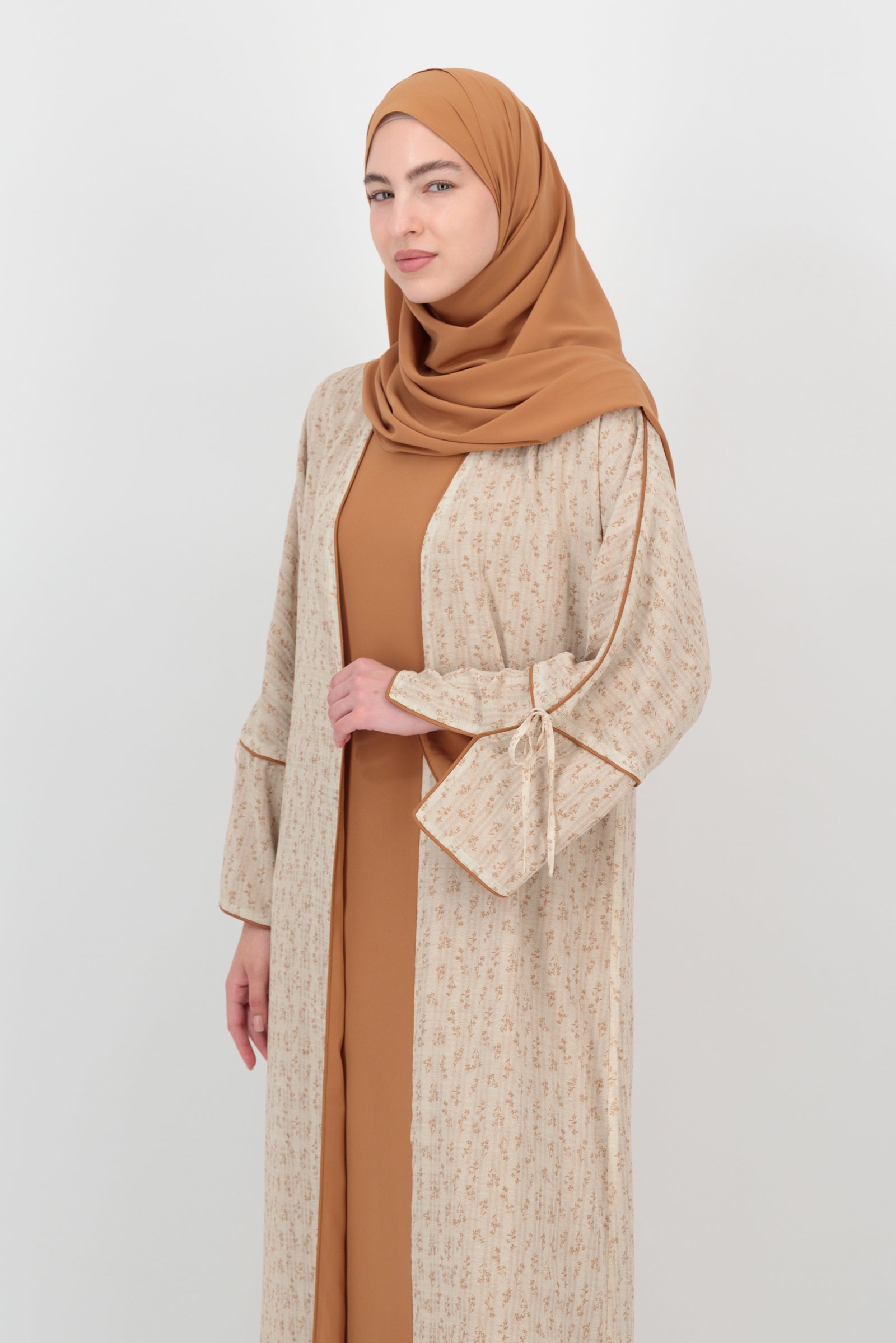 Three-quarter pose of the FARES Printed 3 Piece Abaya Set in Tamr emphasizing the layered outer piece and balanced proportions of this abaya for women.