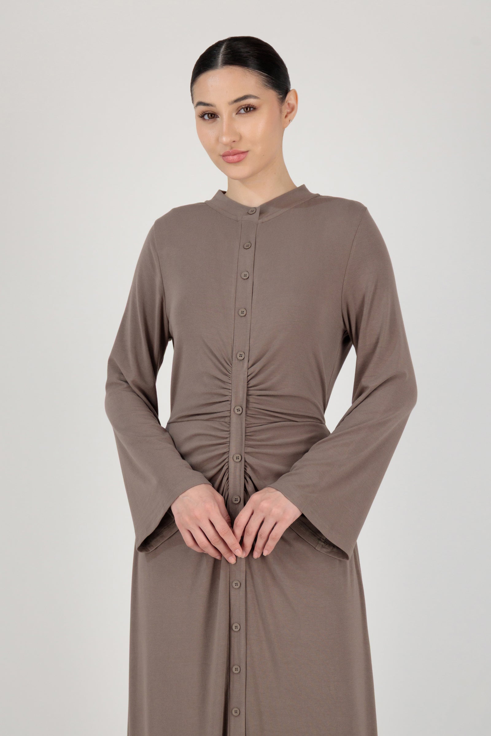Front view of the FARES Gathered Waist Knit Dress in Pebble styled naturally, showing how the gathered waist defines the long sleeve dress.