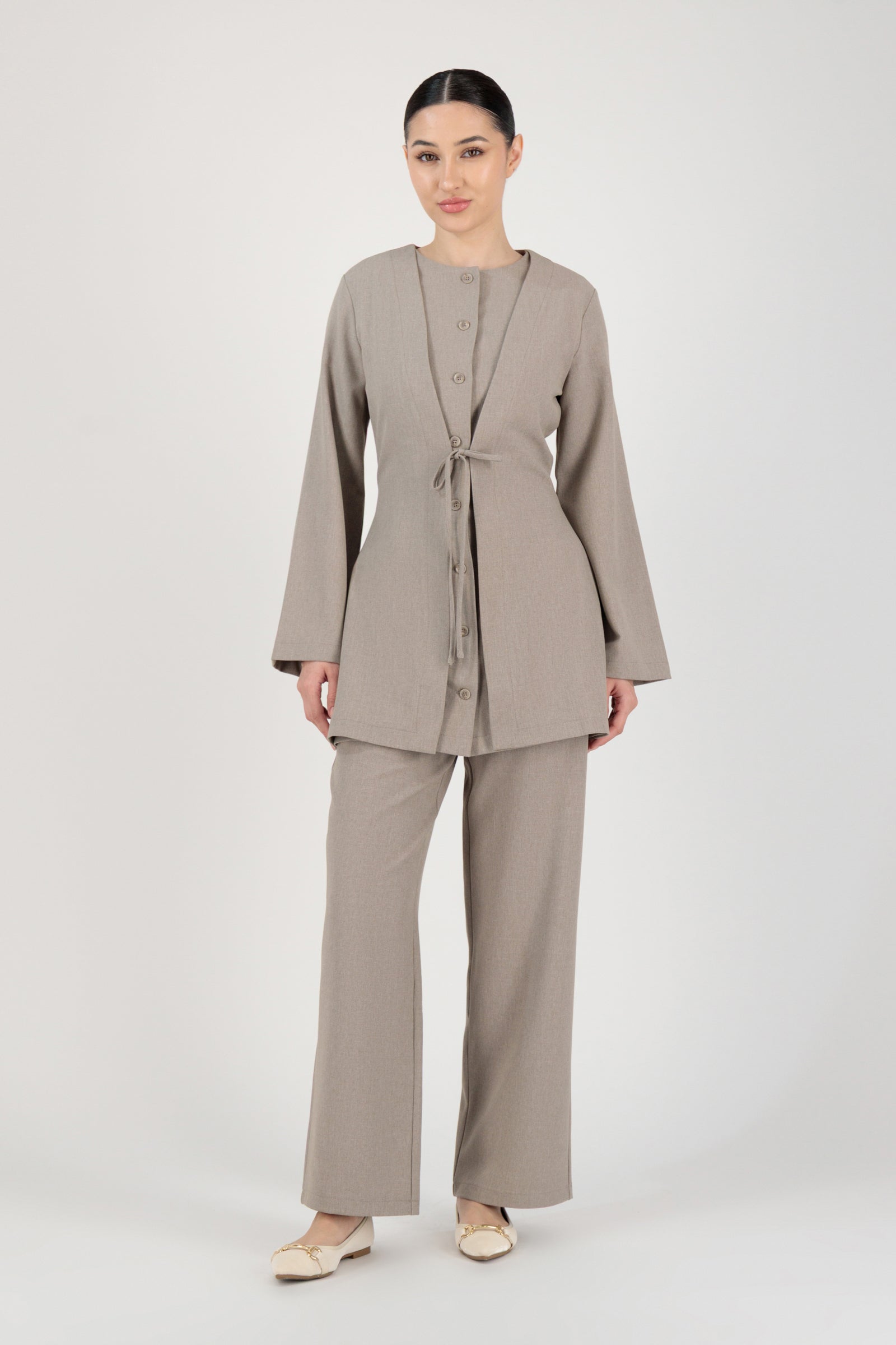 Full-length view of the FARES Tailored Button-Up Tunic in Stone worn as polished tunic clothing paired with matching trousers.