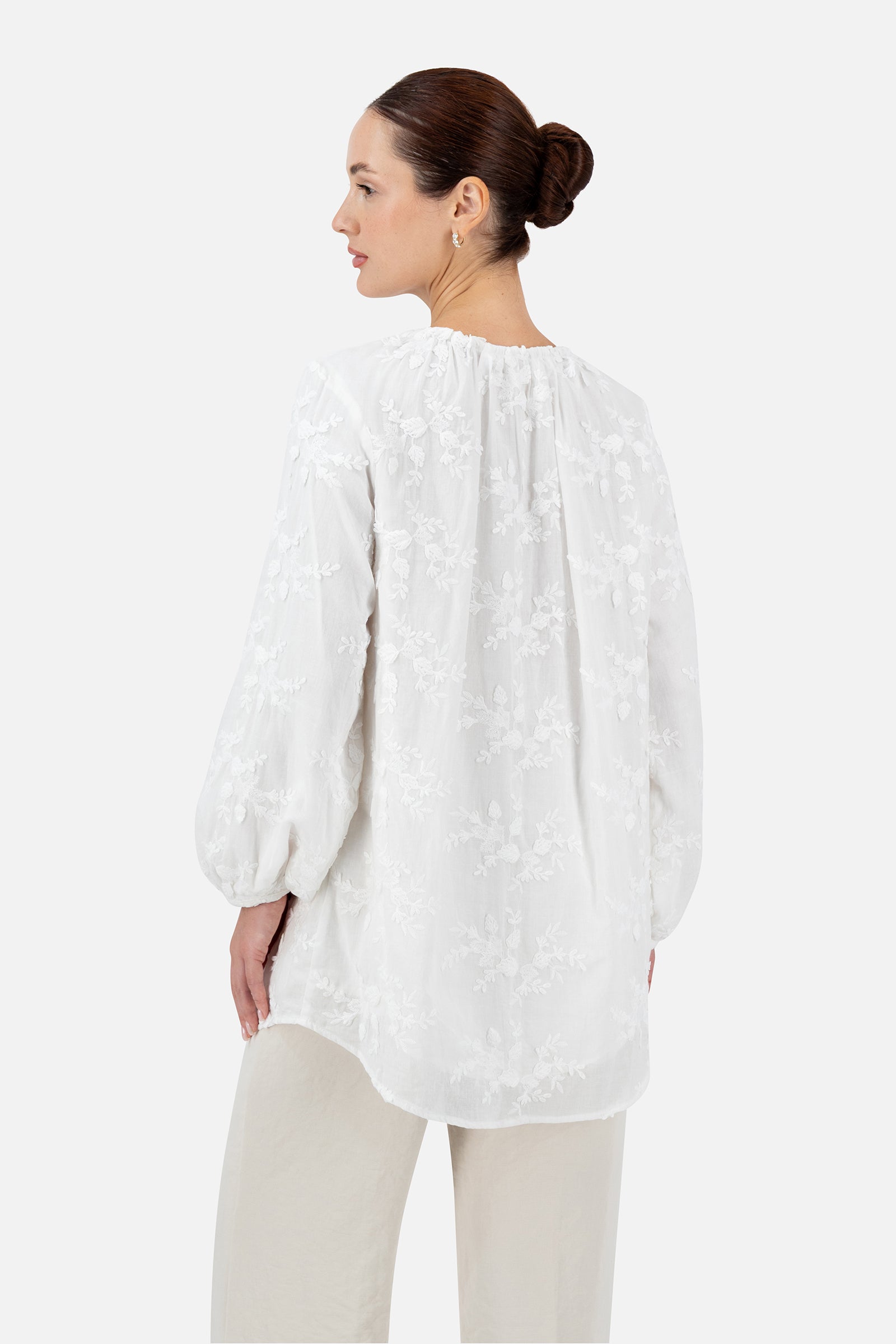 Back view of the white floral embroidered blouse showing the embroidered details.