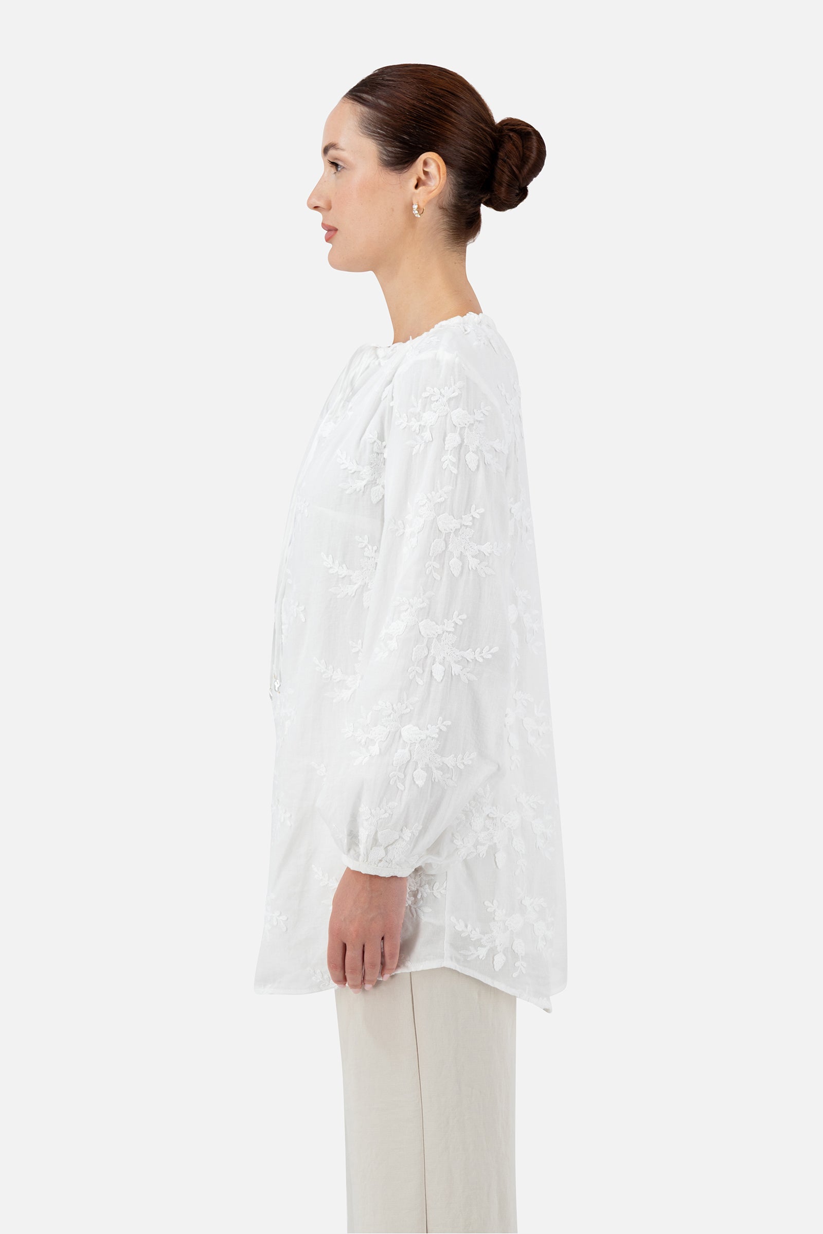 Side profile of the white blouse with a relaxed silhouette.