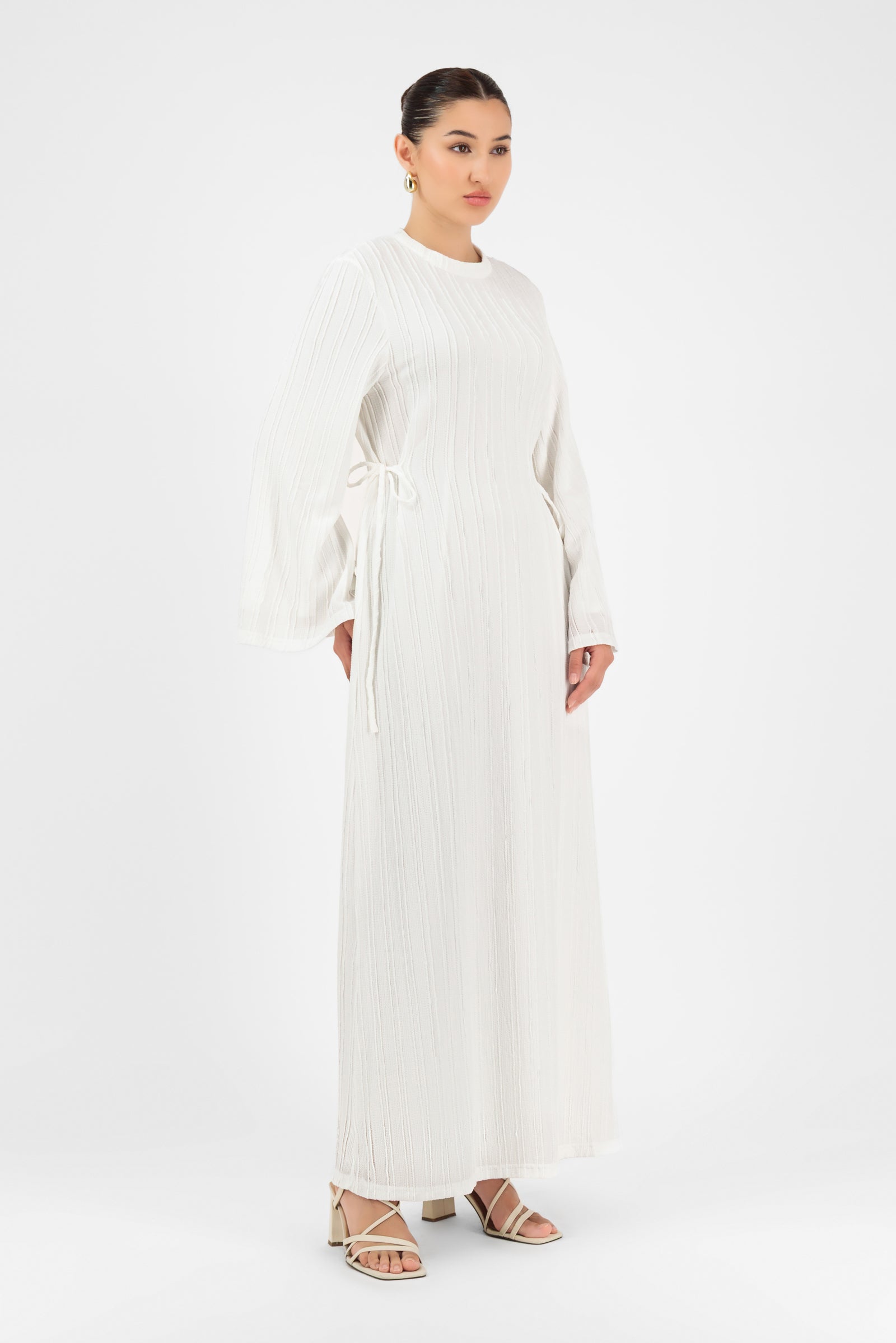 Girl posing in the white textured FARES maxi dress with soft movement and delicate sleeve detailing.