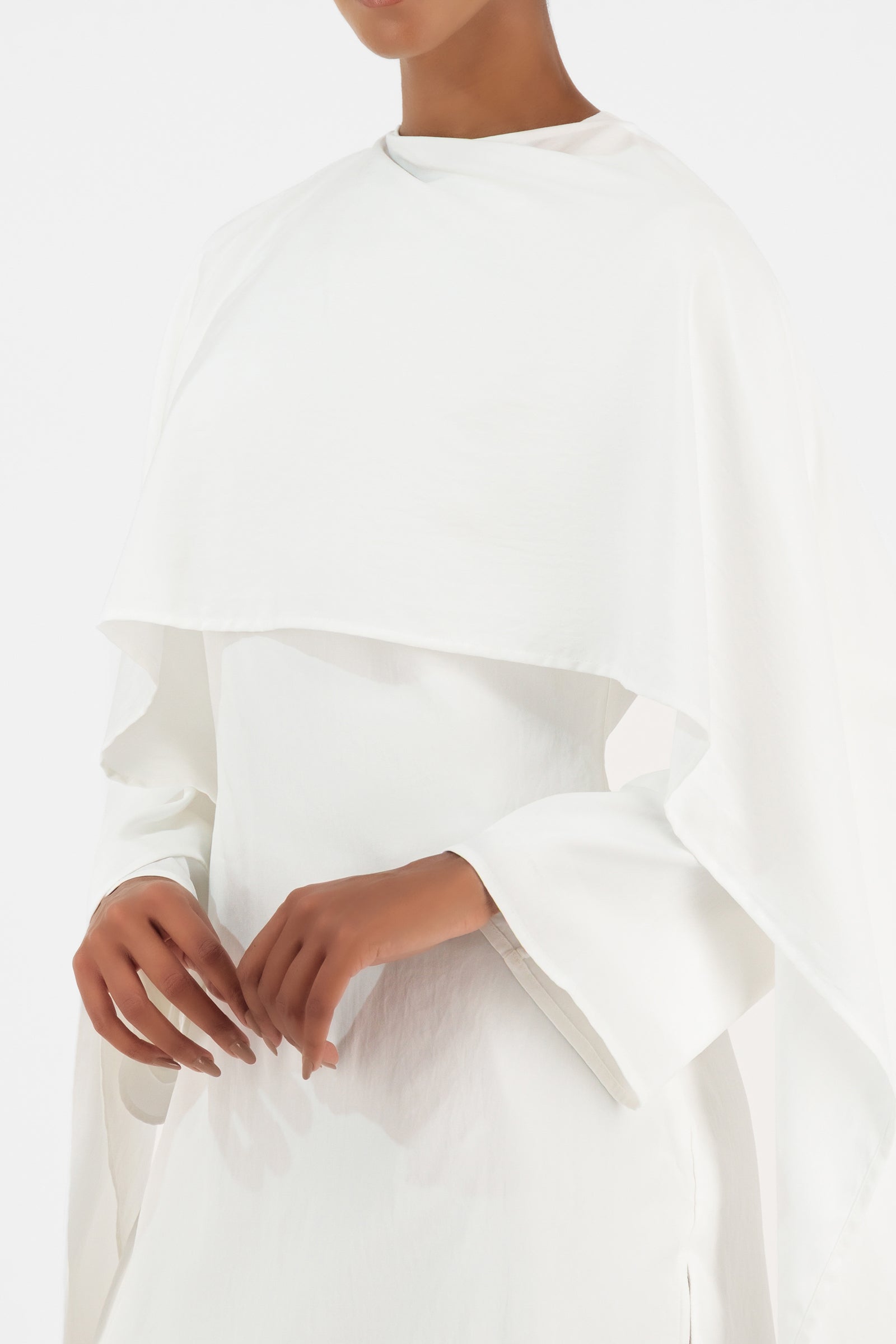 Close-up of the FARES Cape Overlay Tunic in White featuring the soft overlay detail and elevated finishes inspired by timeless tunic clothing.
