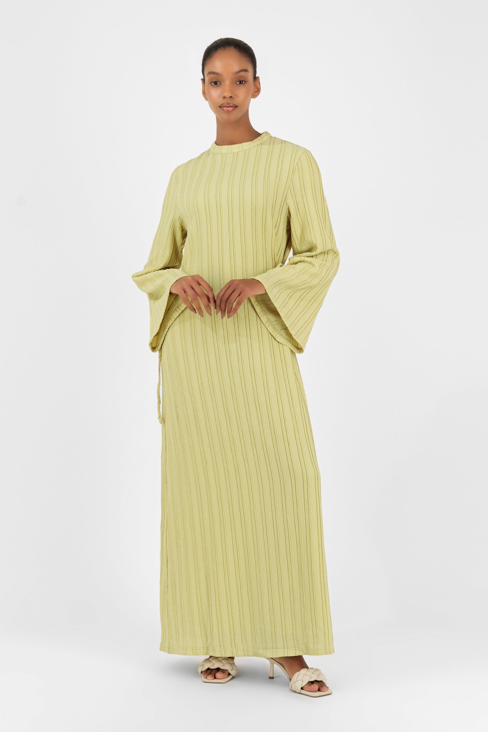 Girl posing in the lime FARES long sleeve maxi dress styled with soft texture and a feminine straight-cut silhouette.