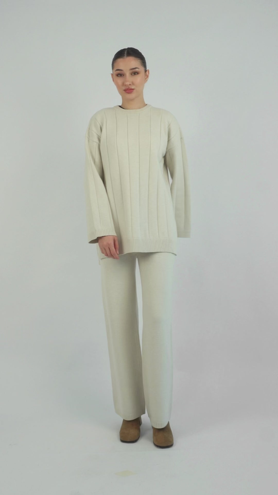 Colour: Cream. A model is posing in a Cloud Knit Sweater