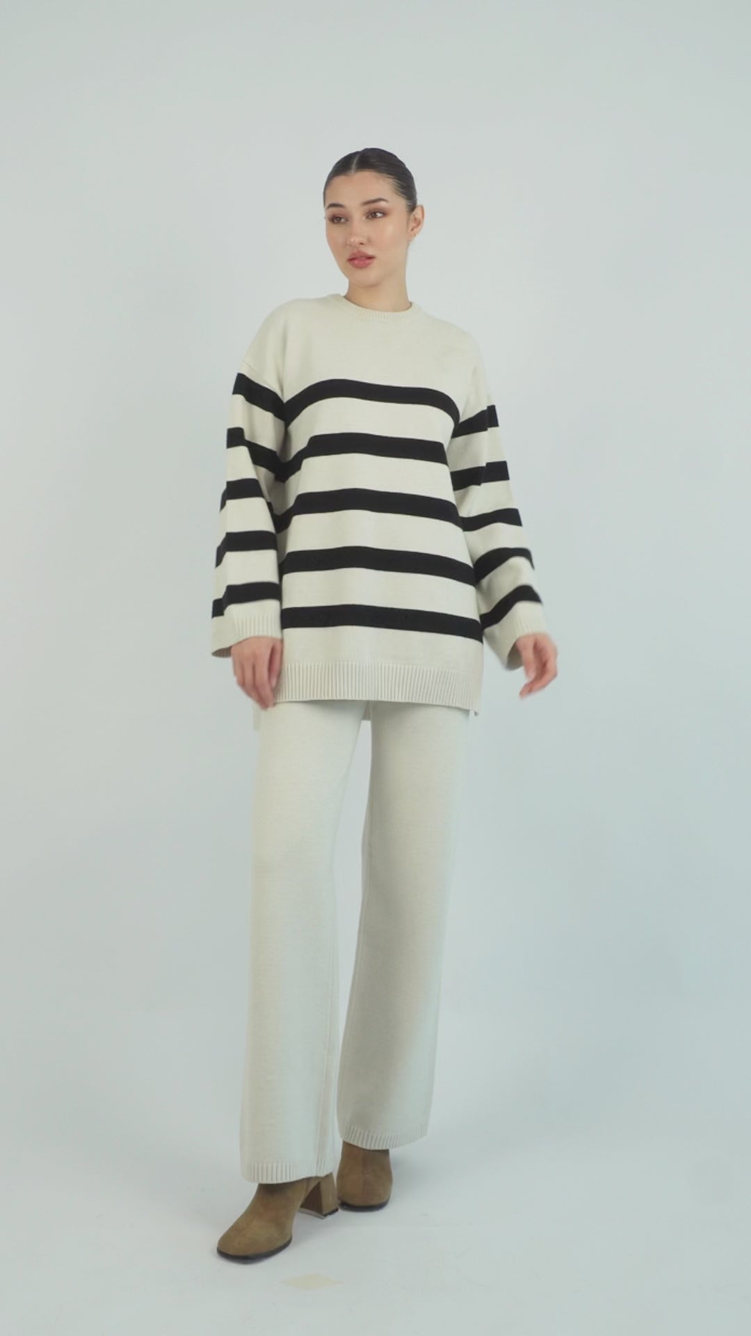 Style: Stripped. A model is posing in a Cloud Knit Sweater