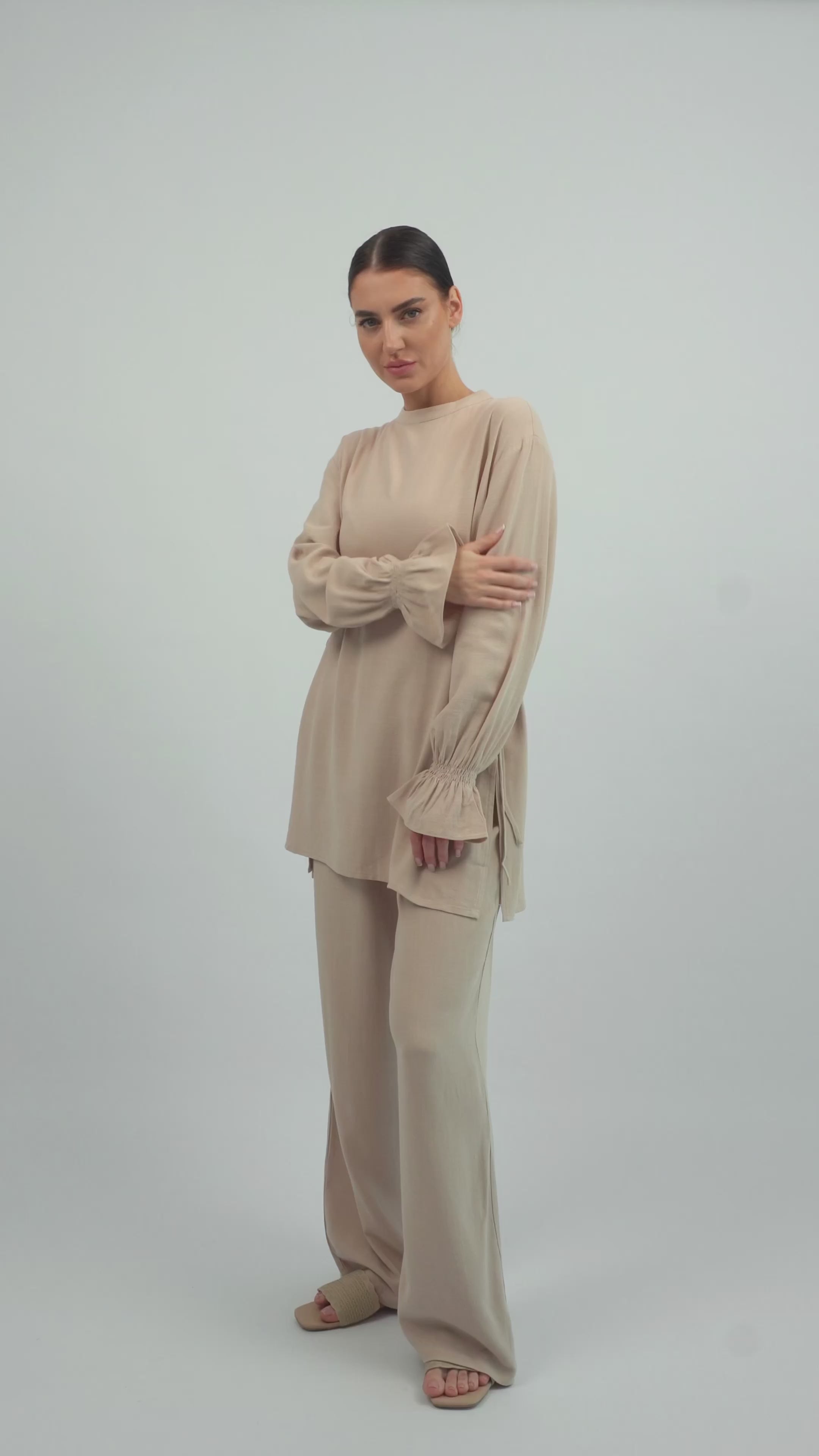 Model walking in the FARES Bow Detail Linen Blend Top in Off-White, showing the natural movement and soft drape of the linen top.