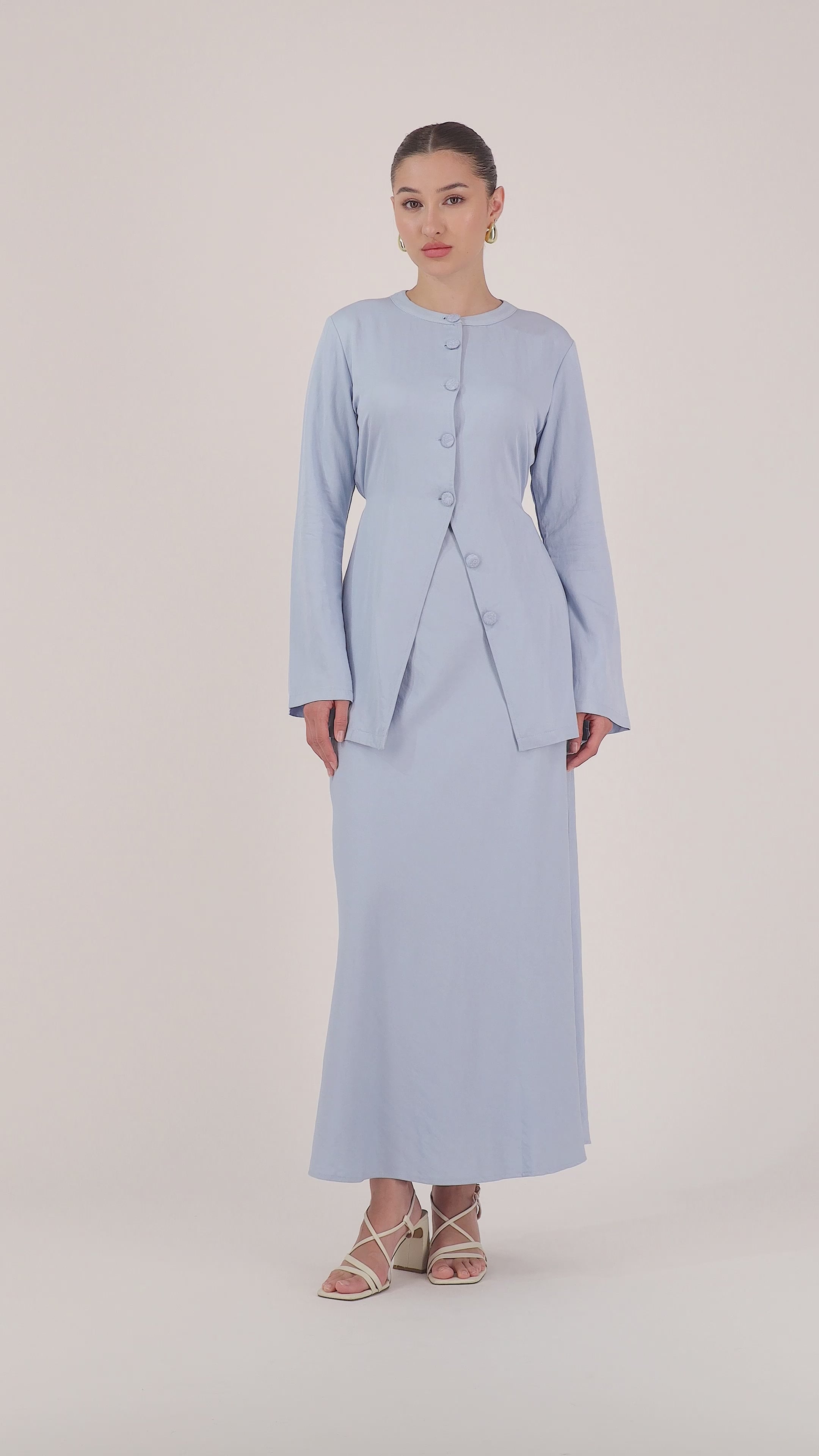 Model walking in the FARES Tailored Vintage Lightweight Cardigan in Powder Blue, showing the flow, length, and soft tailoring of this long cardigan for women.