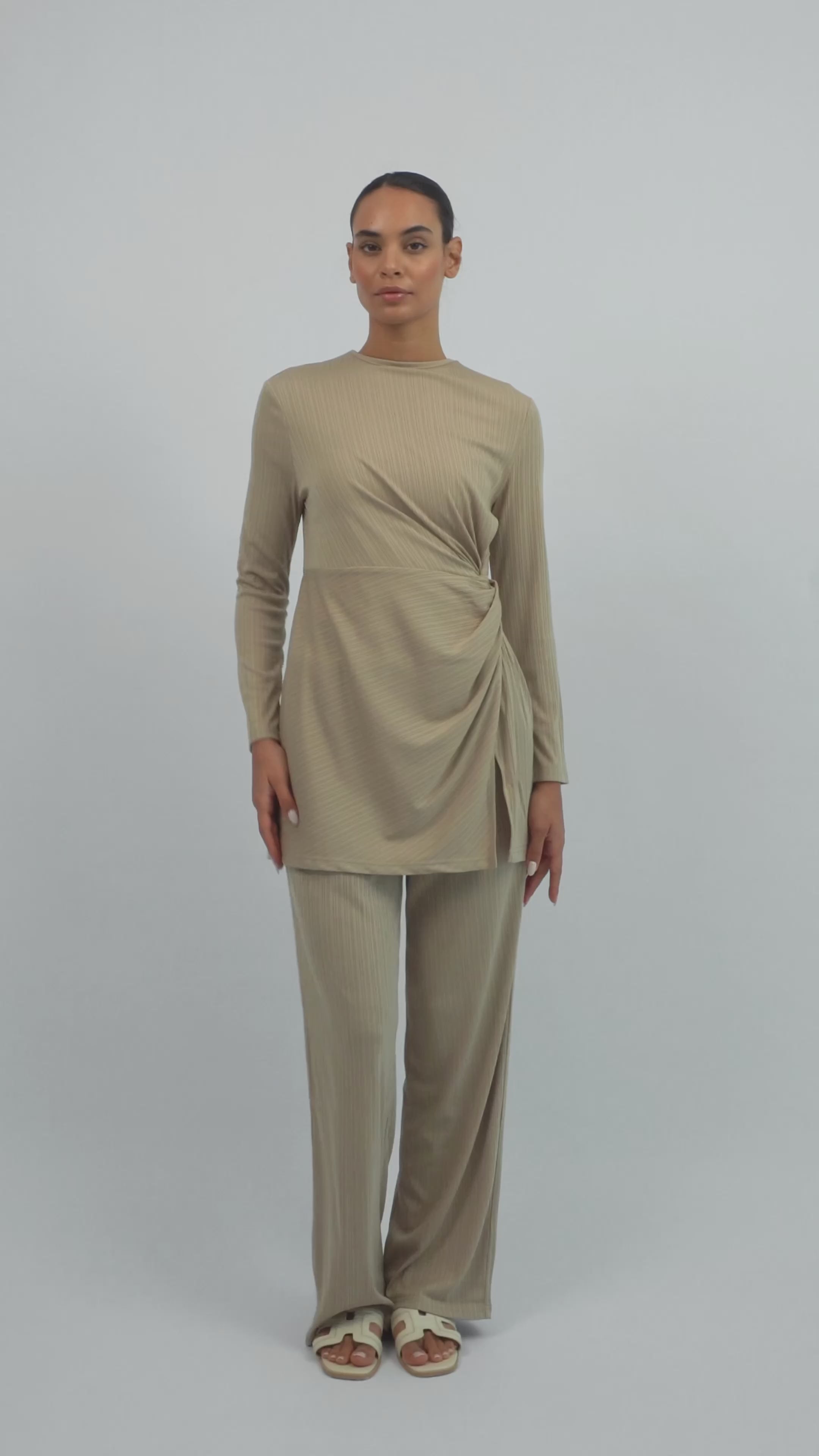 Model walking in the FARES Ribbed Relaxed Fit Pants in Beige, showing the flow, texture, and movement of the relaxed fit pants.