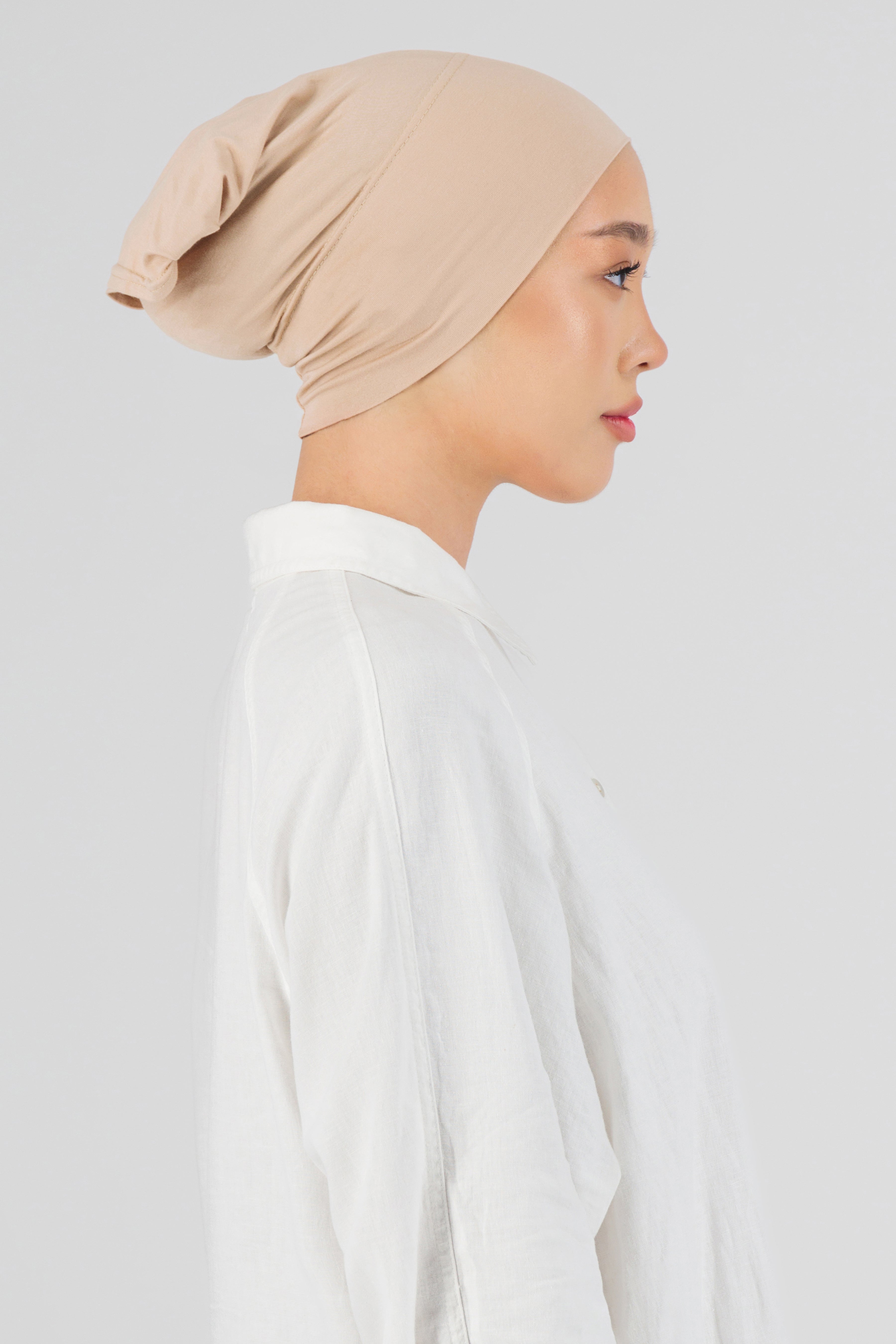 The right profile of a female model wearing a breathable hijab undercap. Colour description: light peach.