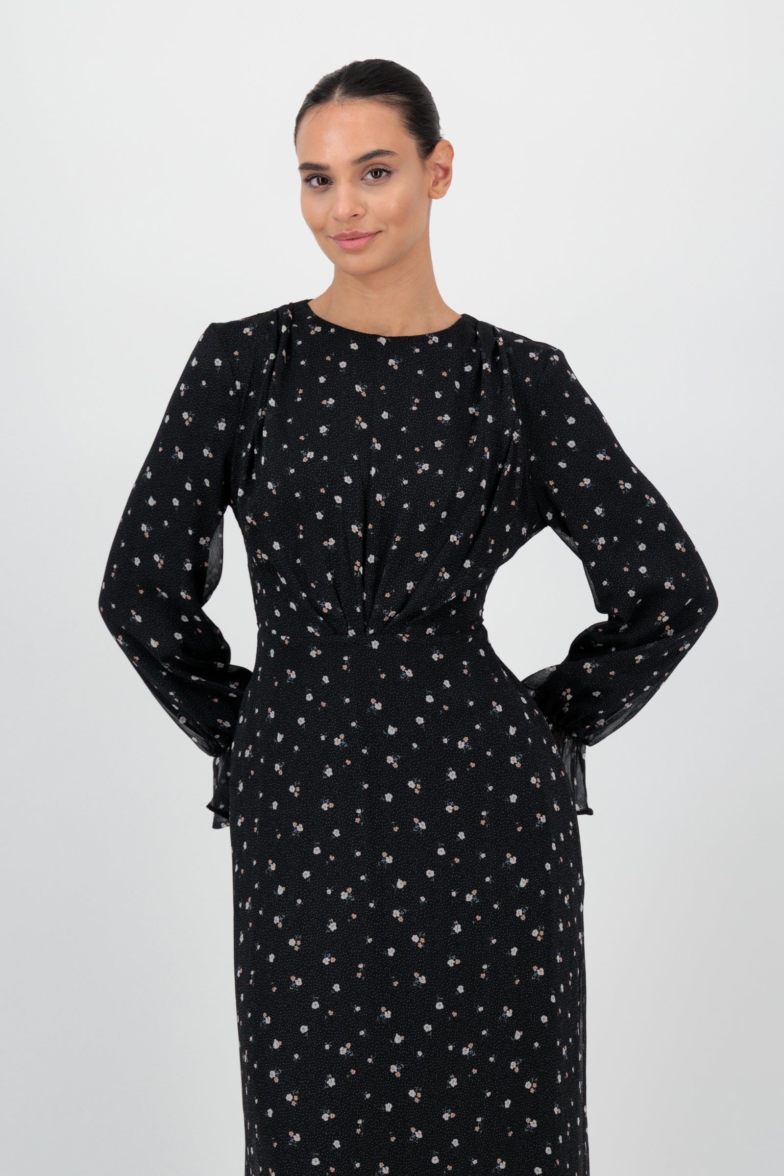 Angled front view of the FARES Waist Wrap Chiffon Dress in Nightbloom emphasizes the cinched waist and delicate movement of this chiffon dress.