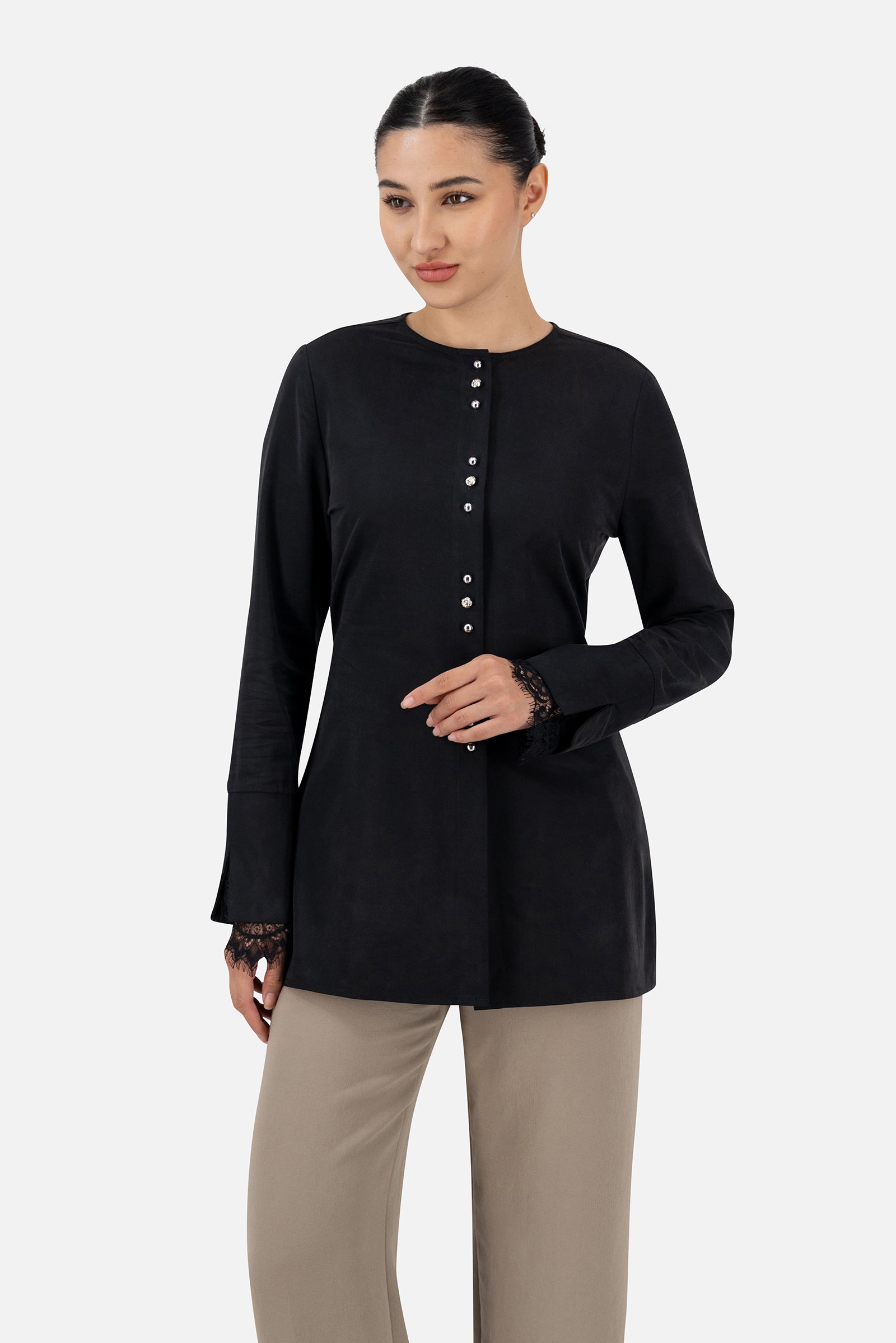 Woman standing in the Black button-up long-sleeve top with matching pants.