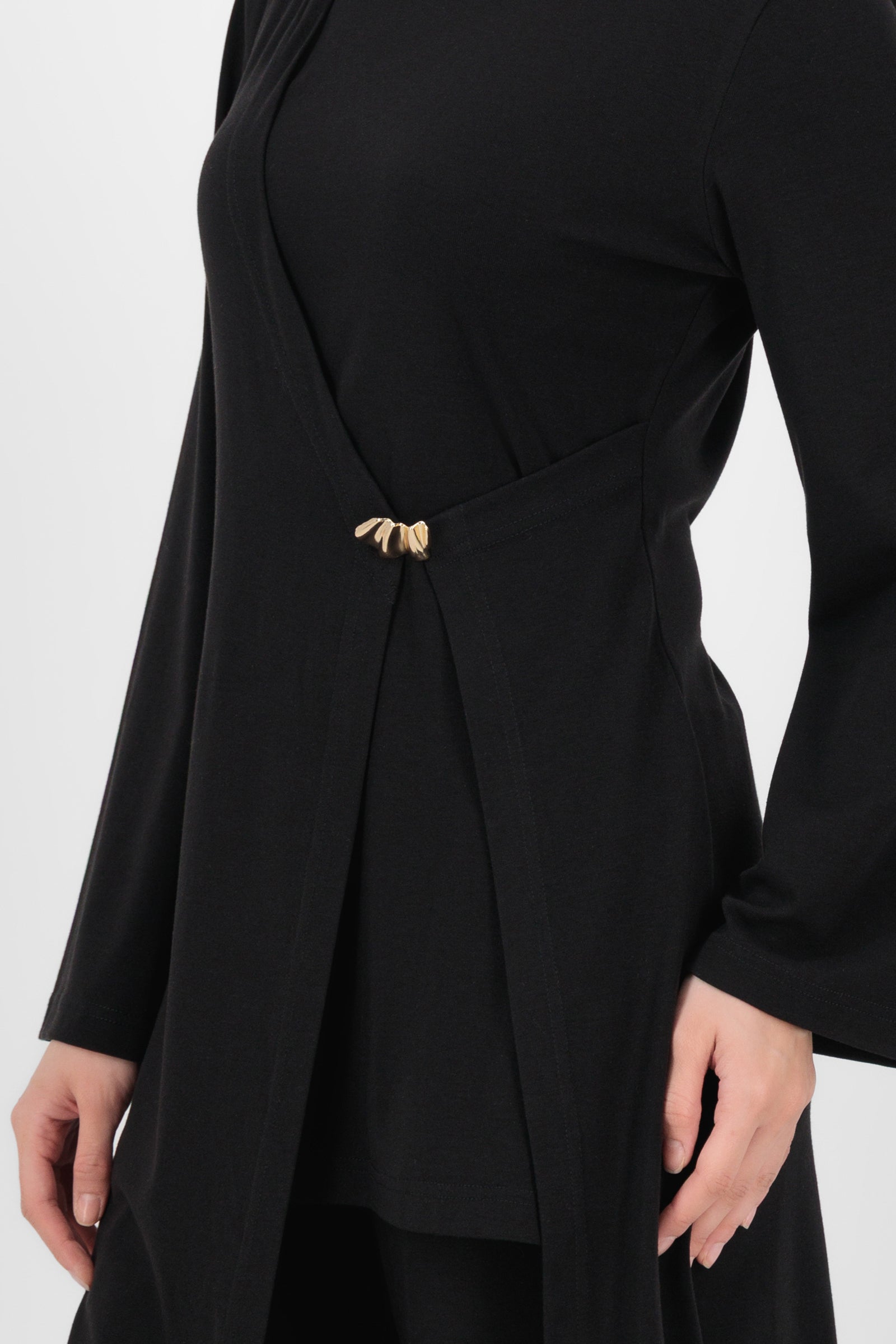 Close-up of the Gold Accent Wrap Top Black showing the textured fabric, gold hardware, and wrap construction that give this long sleeve wrap top its elevated feel.