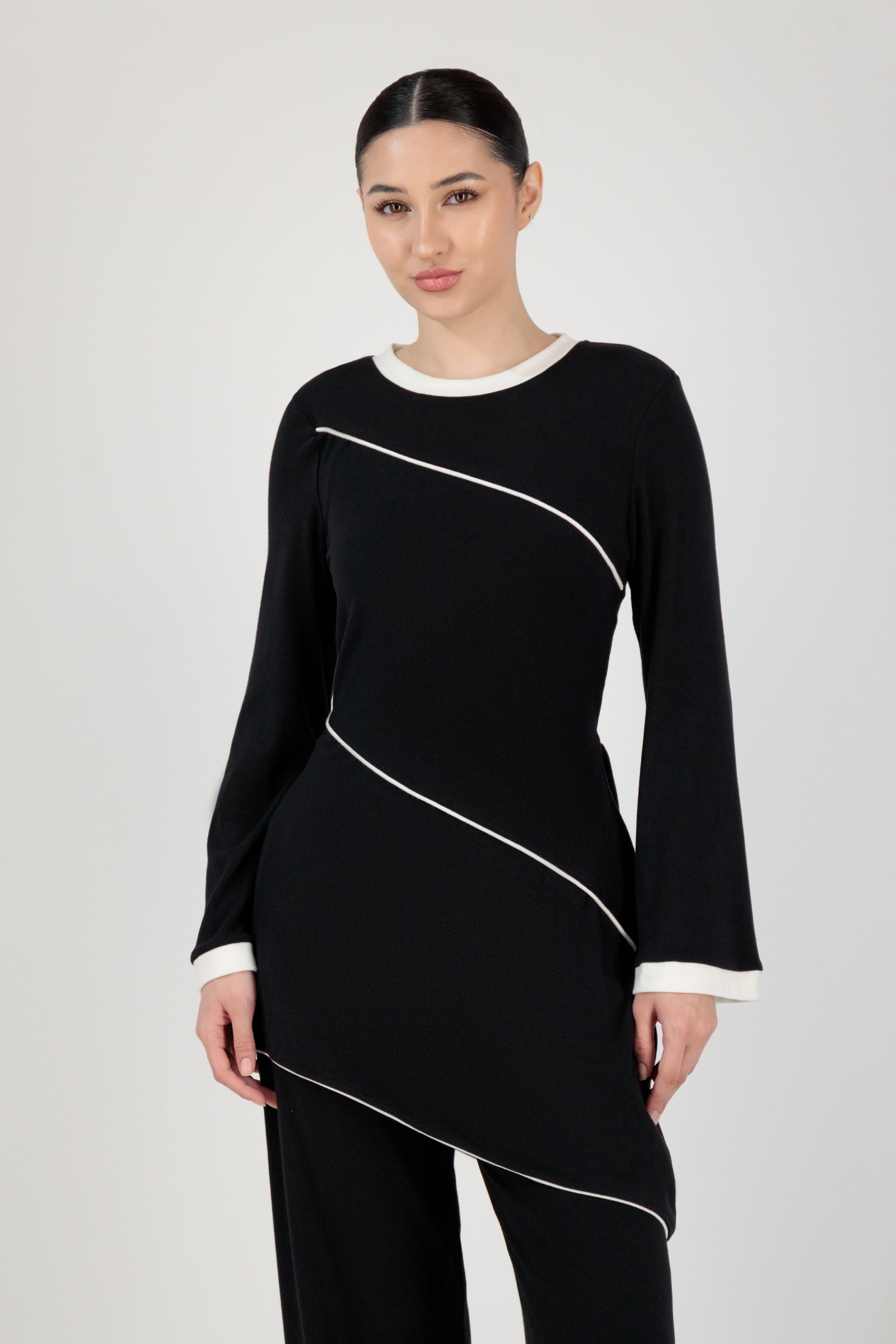 FARES Slanted Contrast Detail Knit Tunic in Black shown from the front as modern tunic clothing with a sharp silhouette and refined button-up inspired detailing.