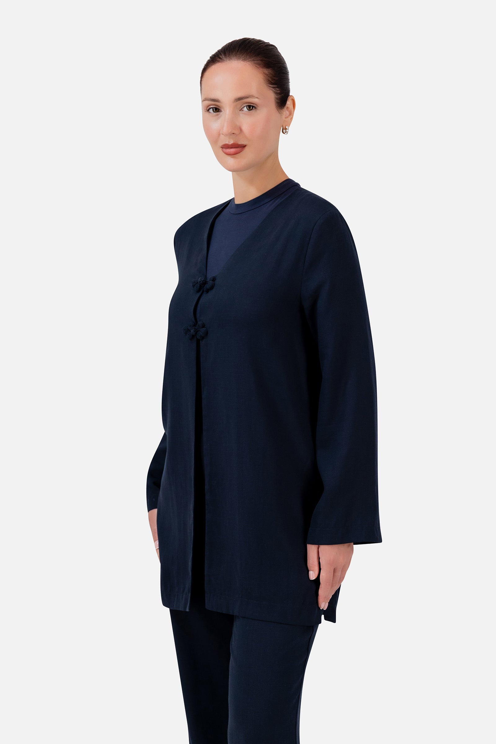 FARES Knot Detail Cardigan in Navy shown at an angle, highlighting the statement knot closures and softly structured shape.