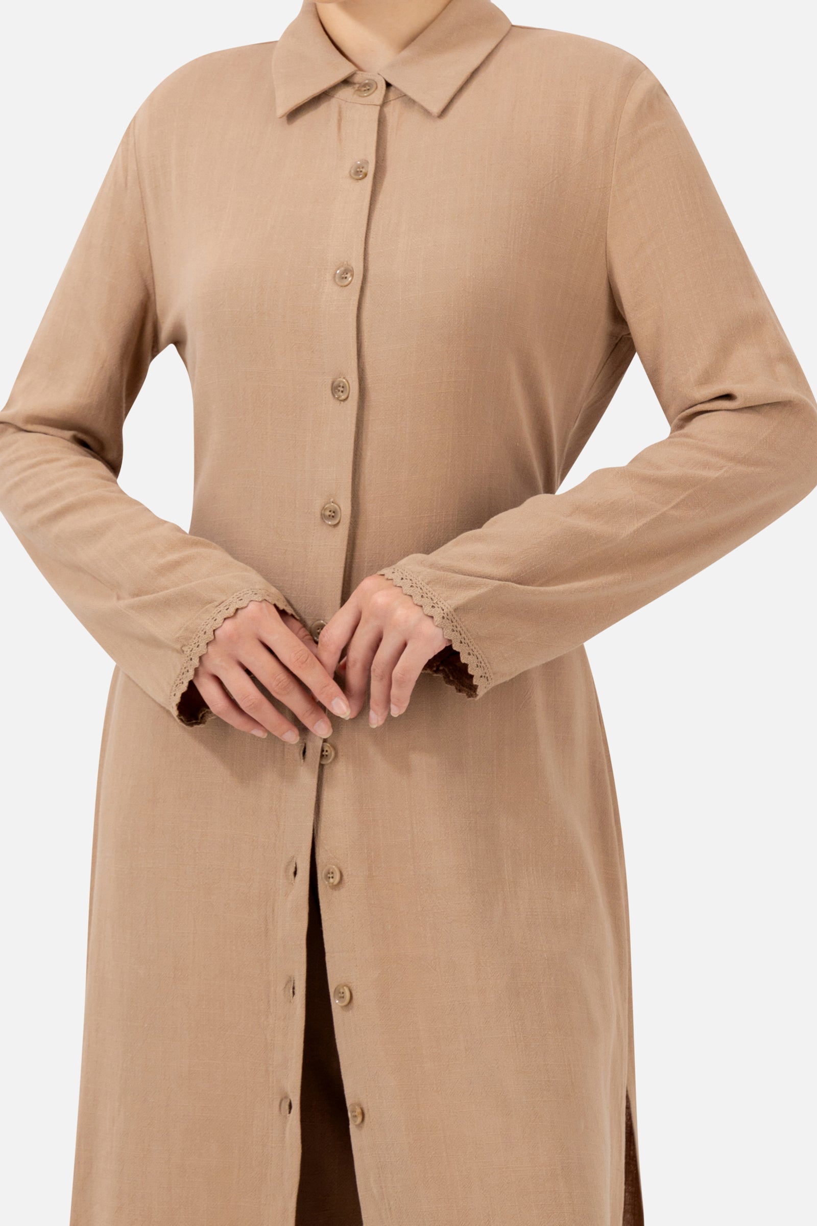 Close-up of the lace trim and button-front detail on the Brownstone long-sleeve tunic.