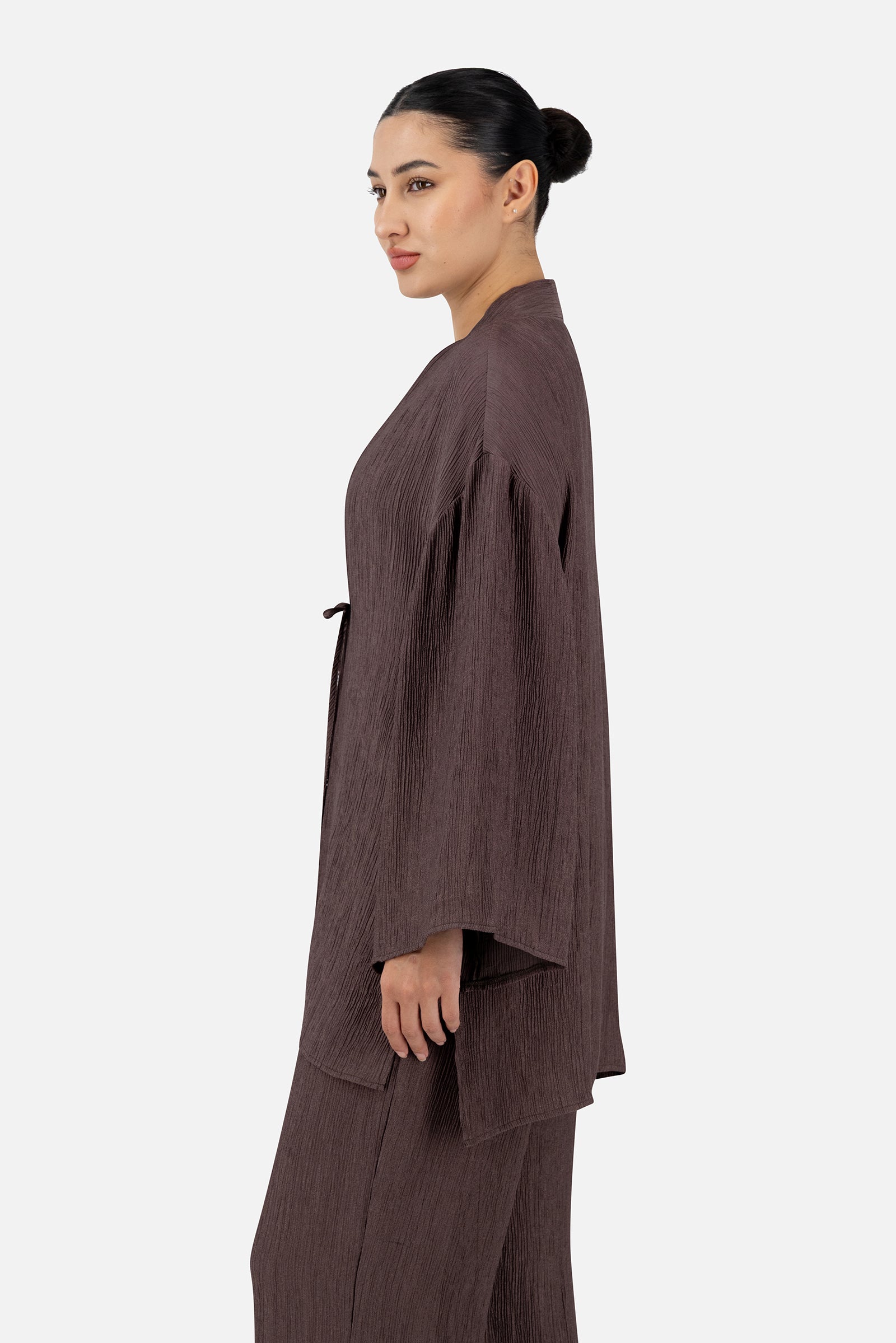 Side profile of the Icy Brown bow cardigan highlighting its flowing shape and textured fabric.