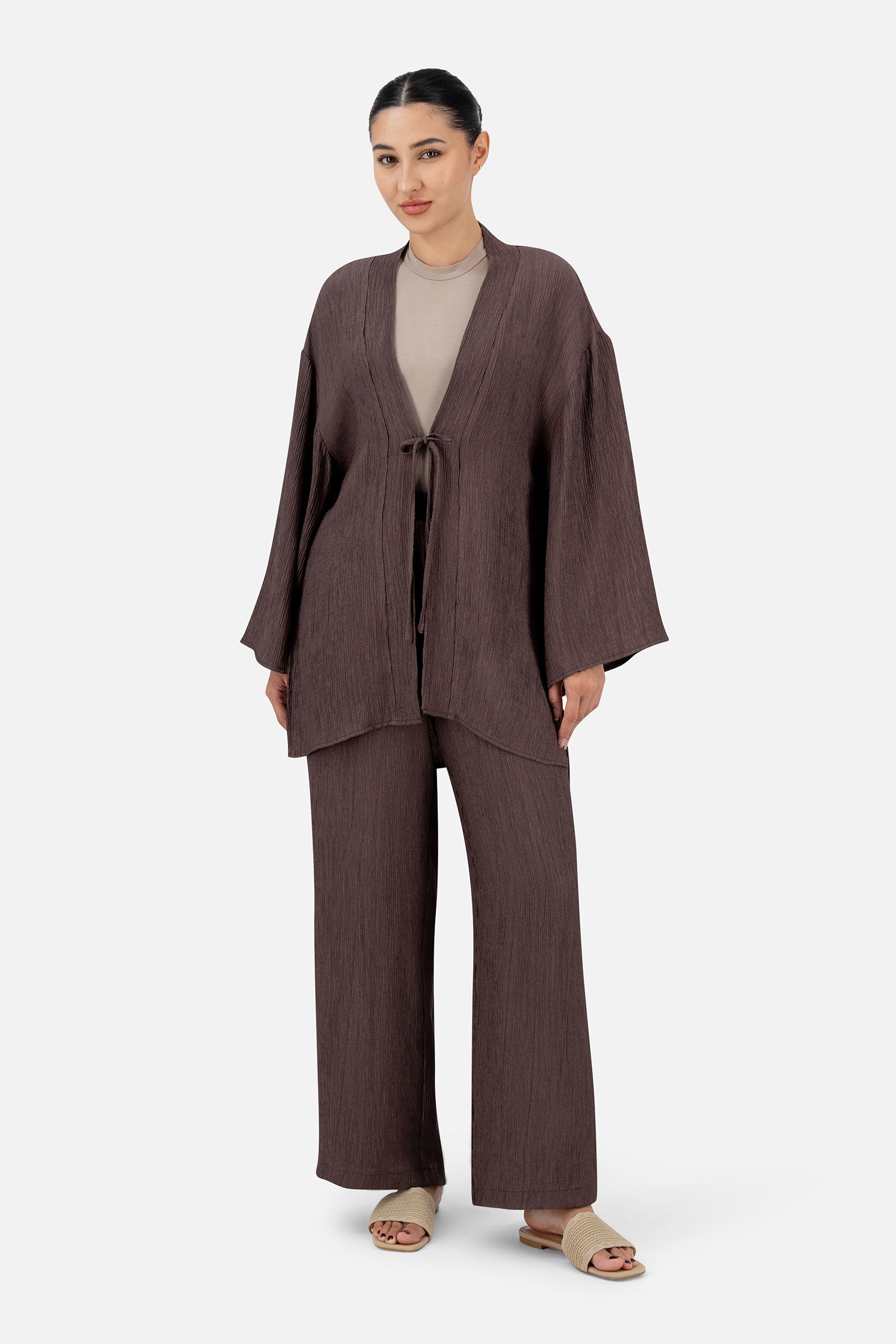 Full-length view of the woman wearing the Icy Brown bow cardigan with matching relaxed fit pants.