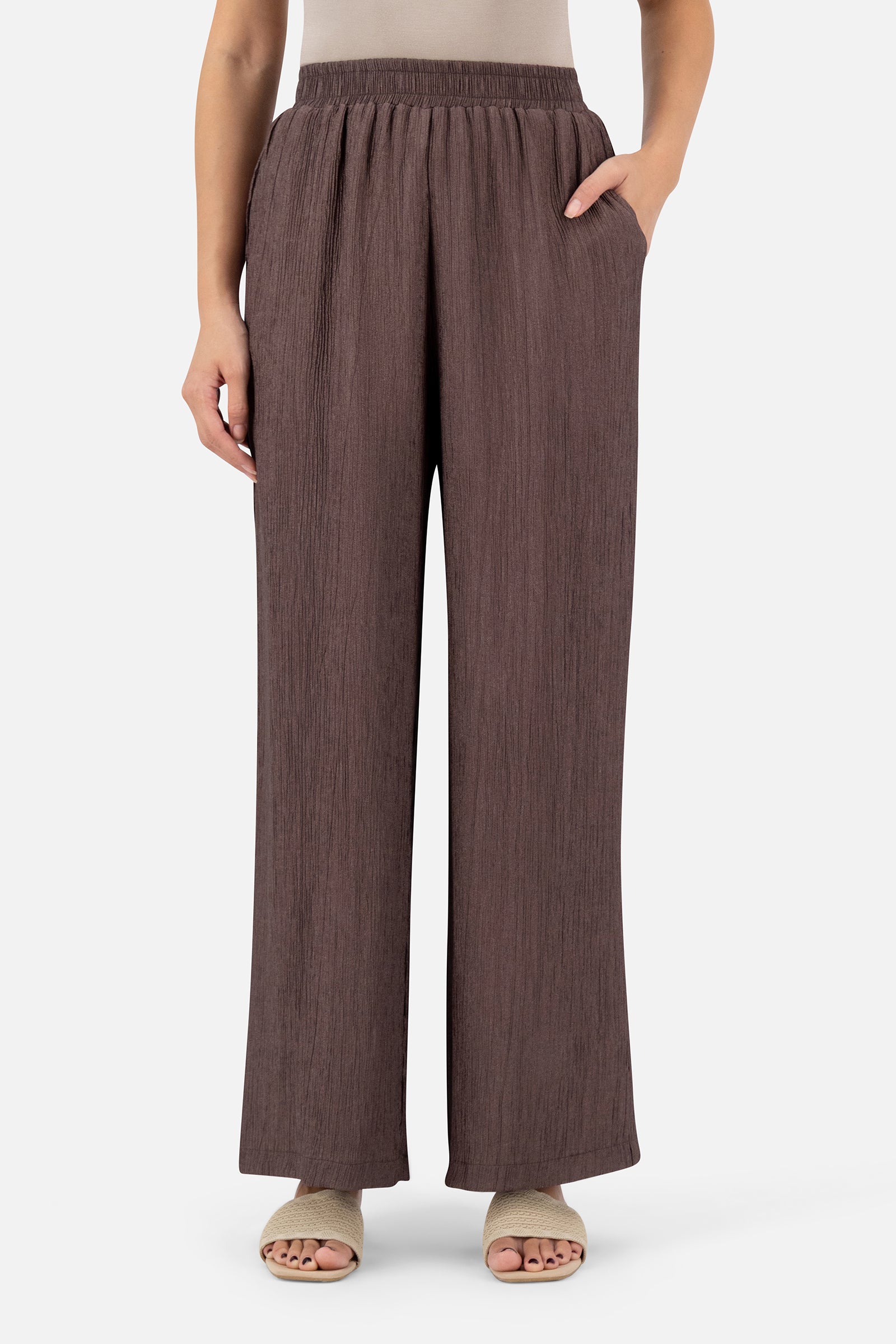 Woman standing in the Icy Brown relaxed fit pants paired with the matching bow cardigan.