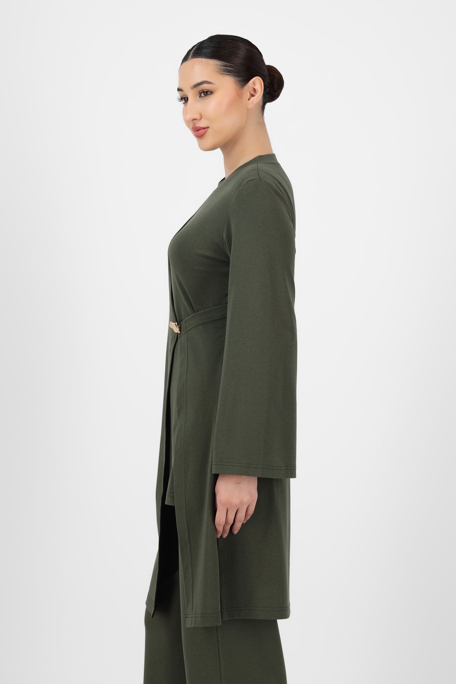 Side angle of the Gold Accent Wrap Top Evergreen capturing the fitted sleeves, soft fabric, and elegant crossover shape that define a refined long sleeve wrap top.