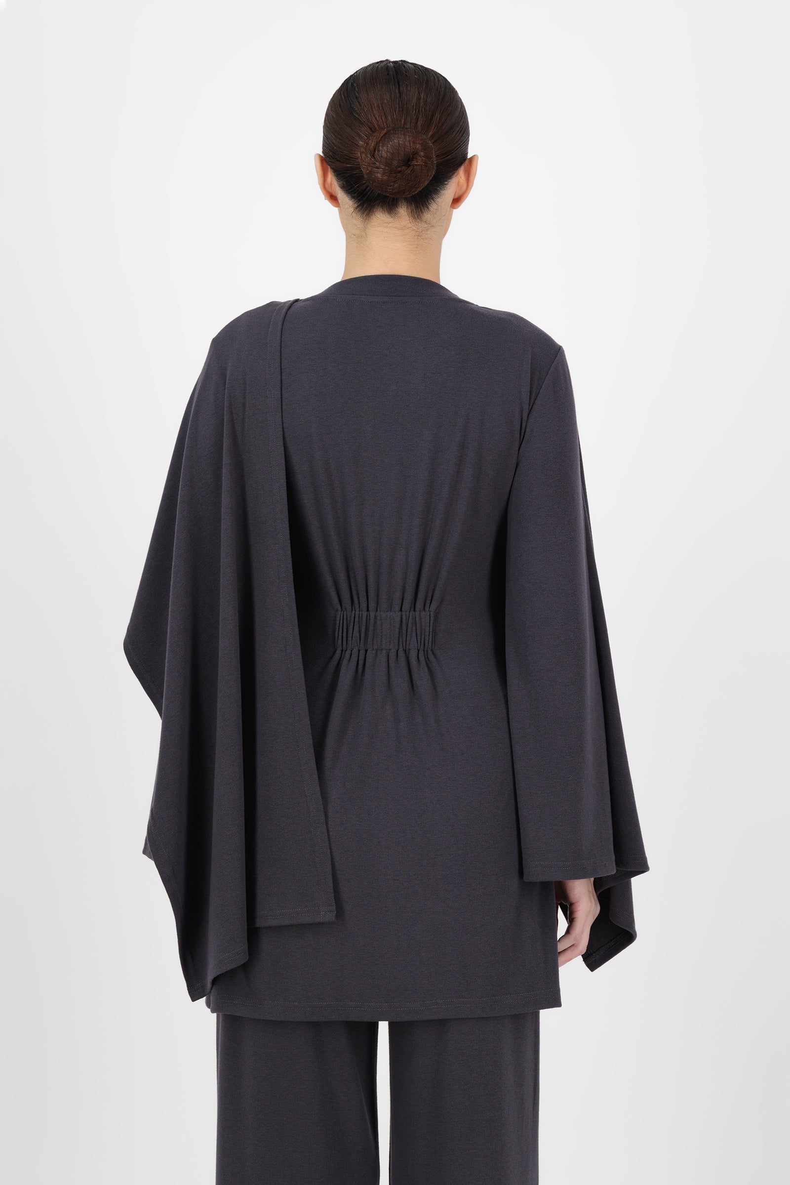 Back view of the Charcoal Draped Shawl Knit Top highlighting the smooth fall of the fabric and relaxed fit that keep knit tops looking refined and effortless.