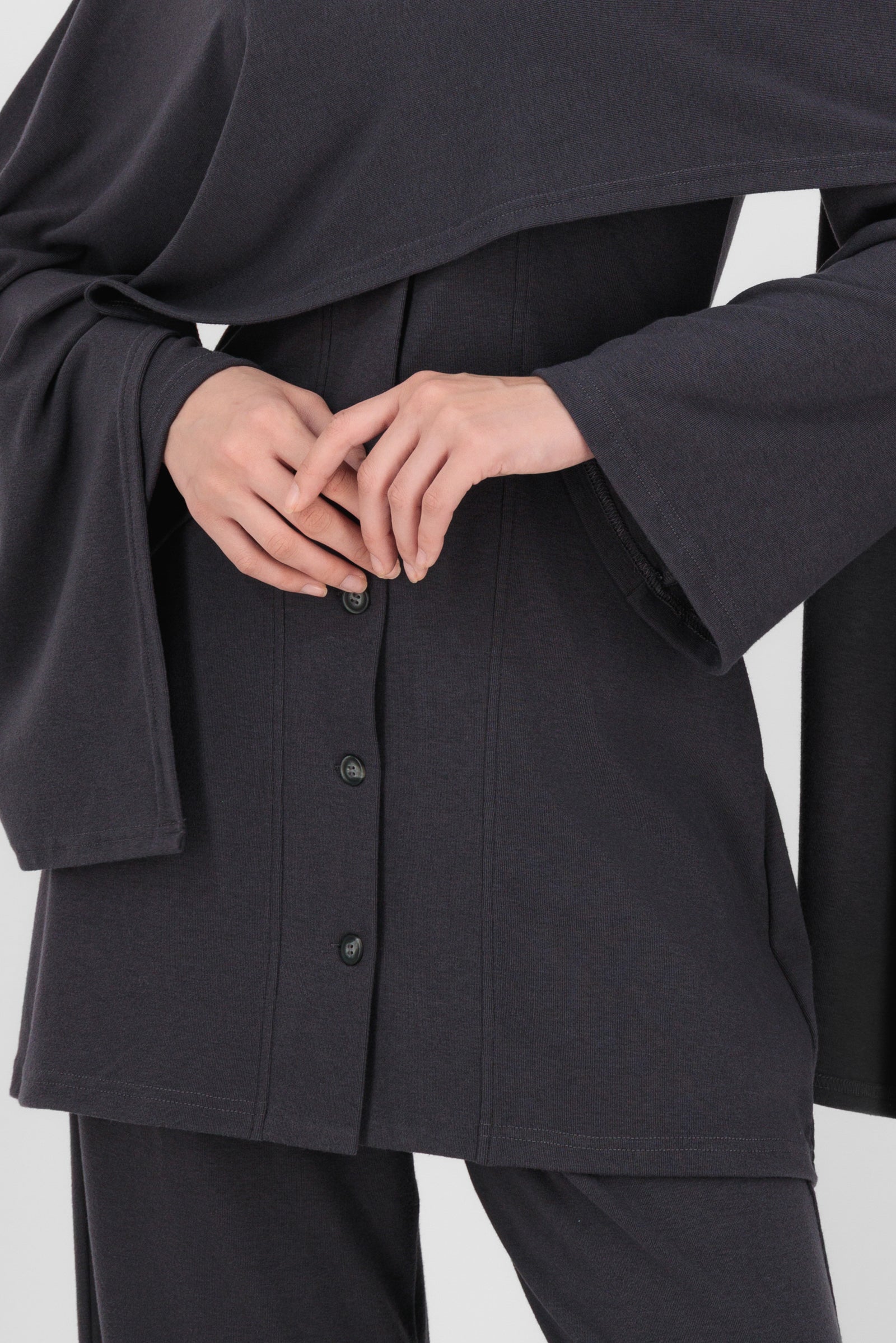 Close-up of the Draped Shawl Knit Top in Charcoal focusing on the soft knit texture, folded shawl detail, and clean stitching that define elevated tops for women.