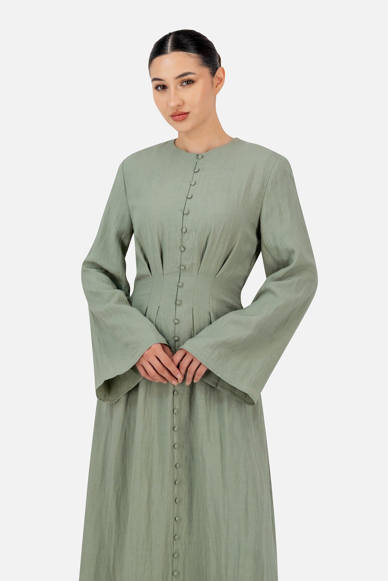Girl posing in the clover FARES maxi dress with wide sleeves and delicate front pleat detailing.