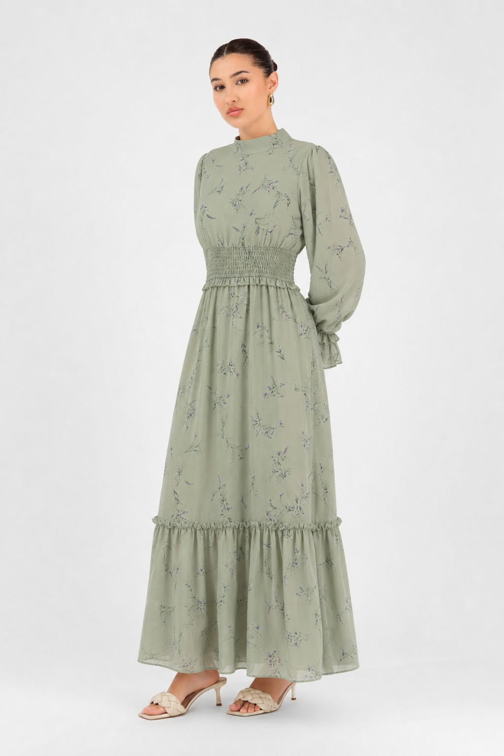 Woman standing in the Sage Meadow printed maxi dress with long sleeves and a shirred waist.