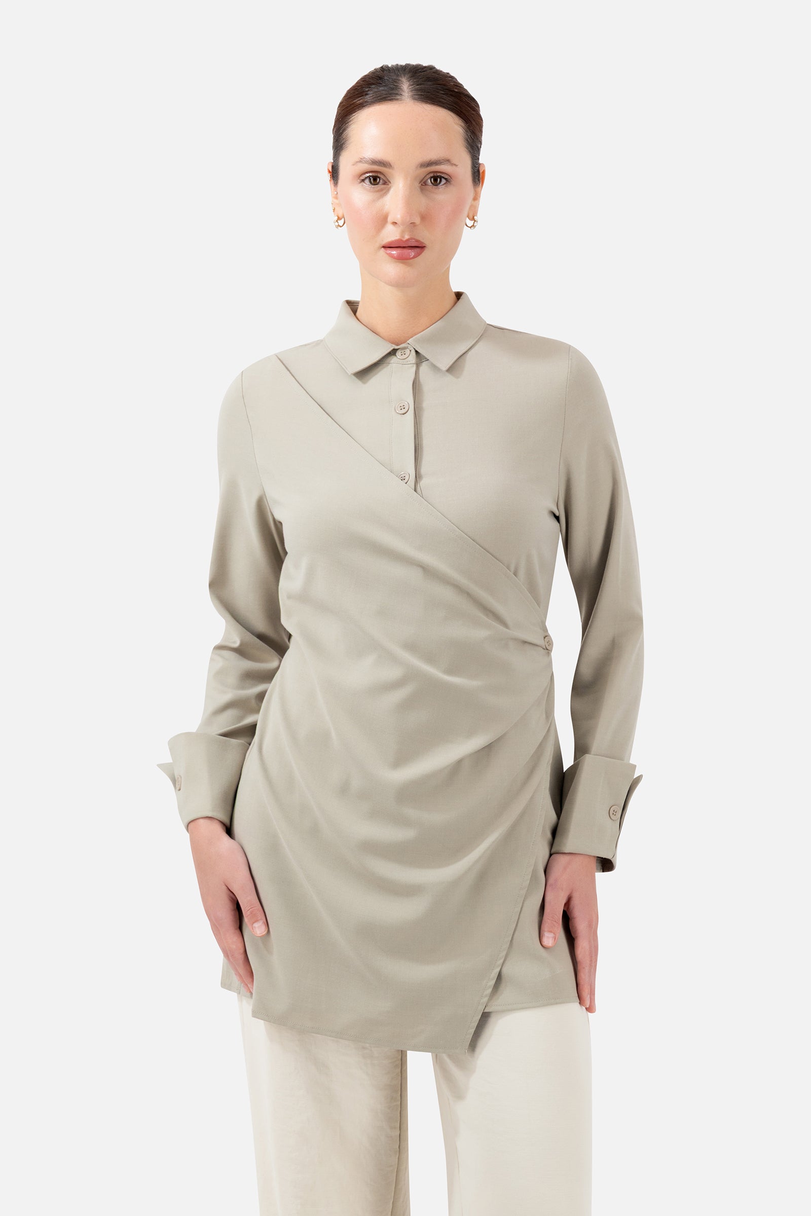 Woman wearing the Antique Green Wrap Detail Button-Up Shirt, front view with an elegant wrap detail and flattering silhouette.