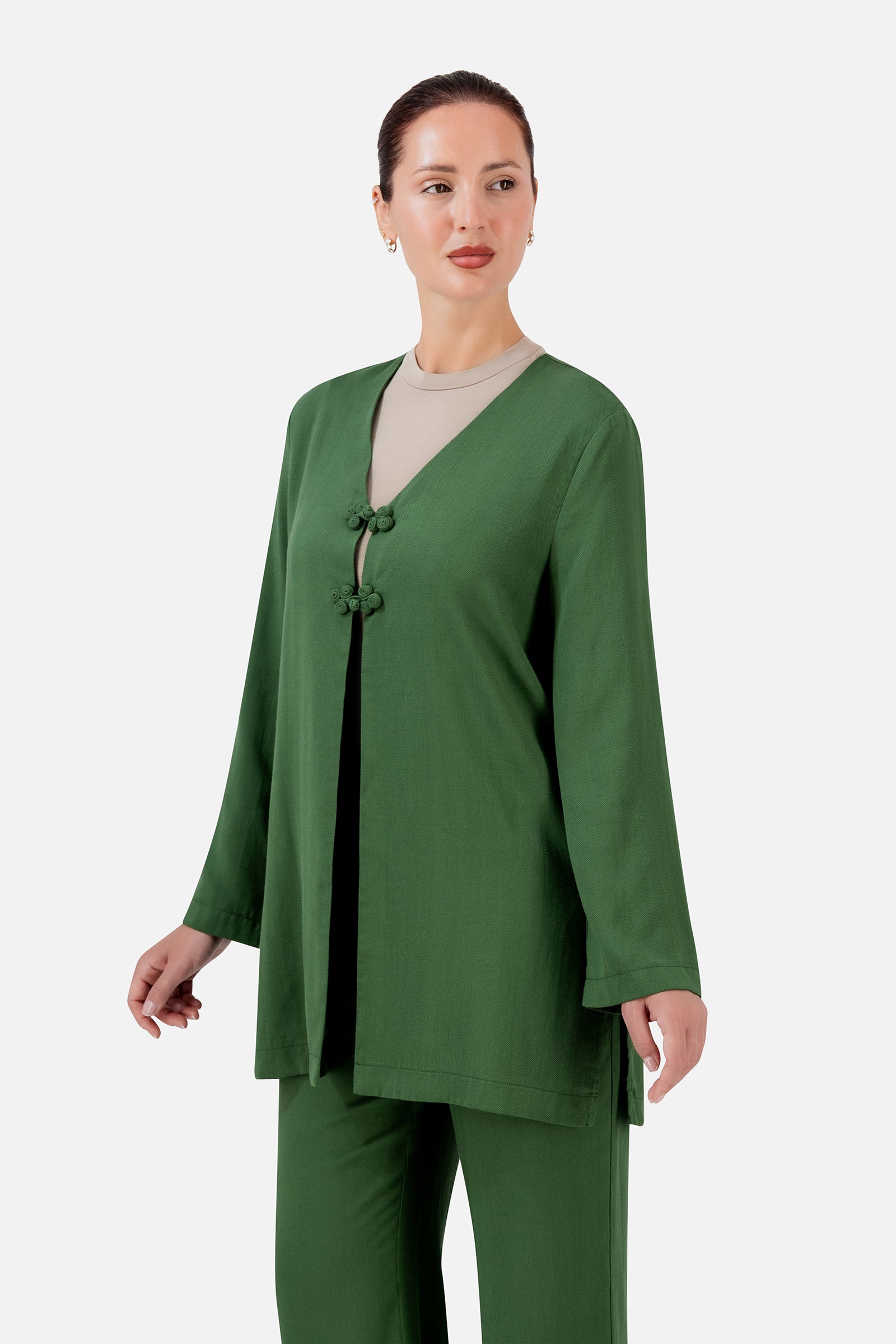 FARES Knot Detail Cardigan in Evergreen shown at an angle, highlighting the knotted front closures and softly flowing shape.