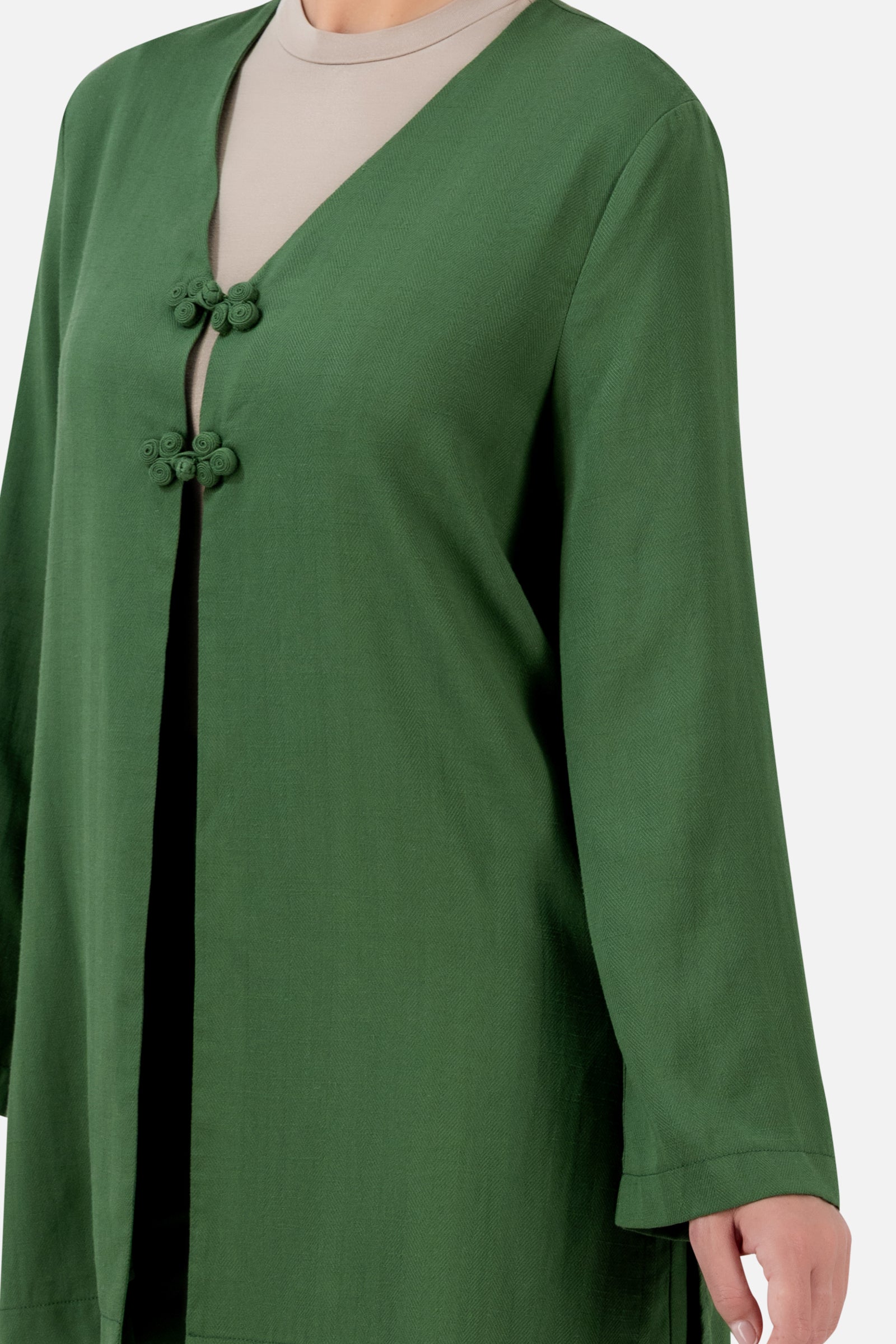 Closer view of the FARES Knot Detail Cardigan in Evergreen, highlighting the statement knot closures, V-neckline and wide sleeves.