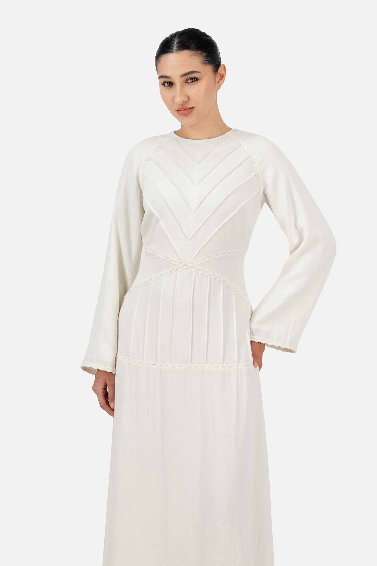 Model posing in the White Ivory geometric detail maxi dress with long sleeves.