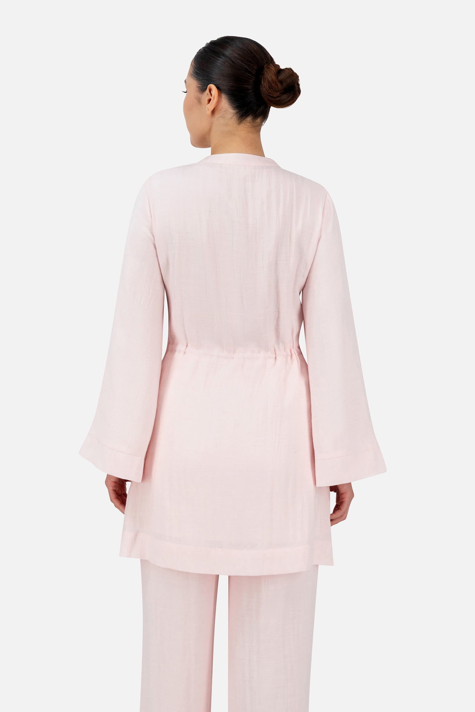 Back view of a woman wearing the Strawberry Cream FARES tunic clothing set showcasing the adjustable drawstring waist and flowing fit.