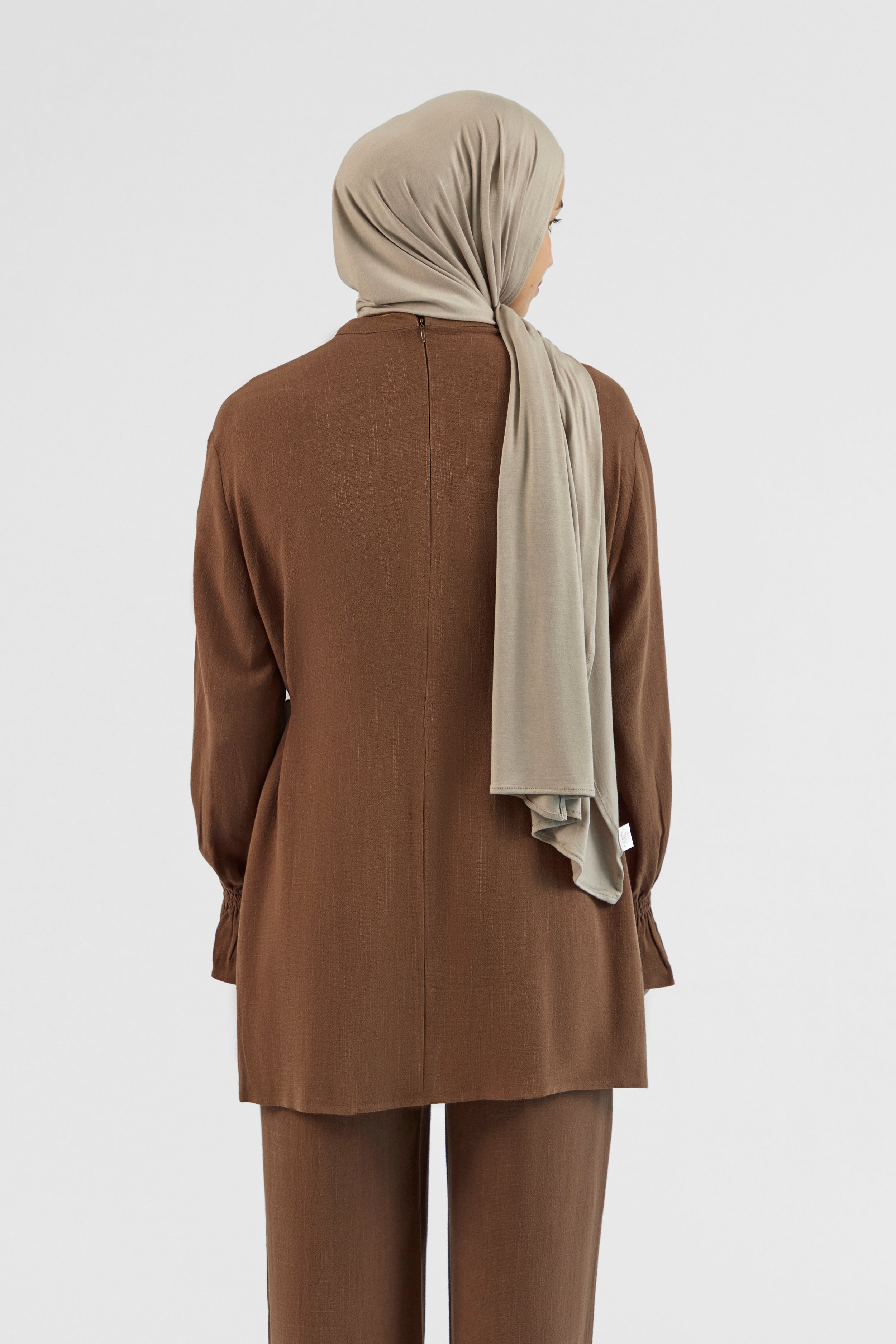 Colour: Chocolate. The back of a model wearing a Bow Detail Linen Blend Top.