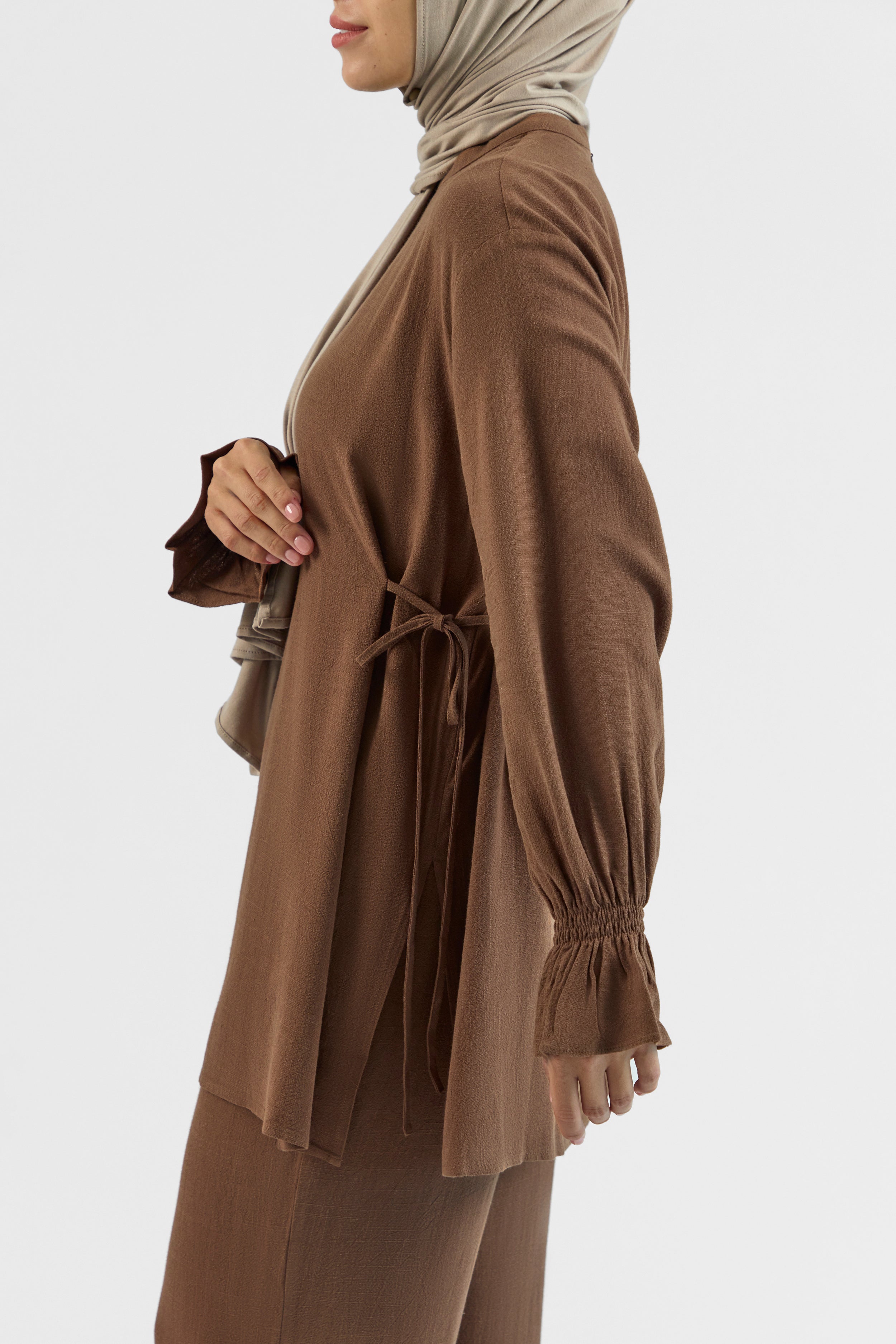 Colour: Chocolate. A model is turned left in a Bow Detail Linen Blend Top.