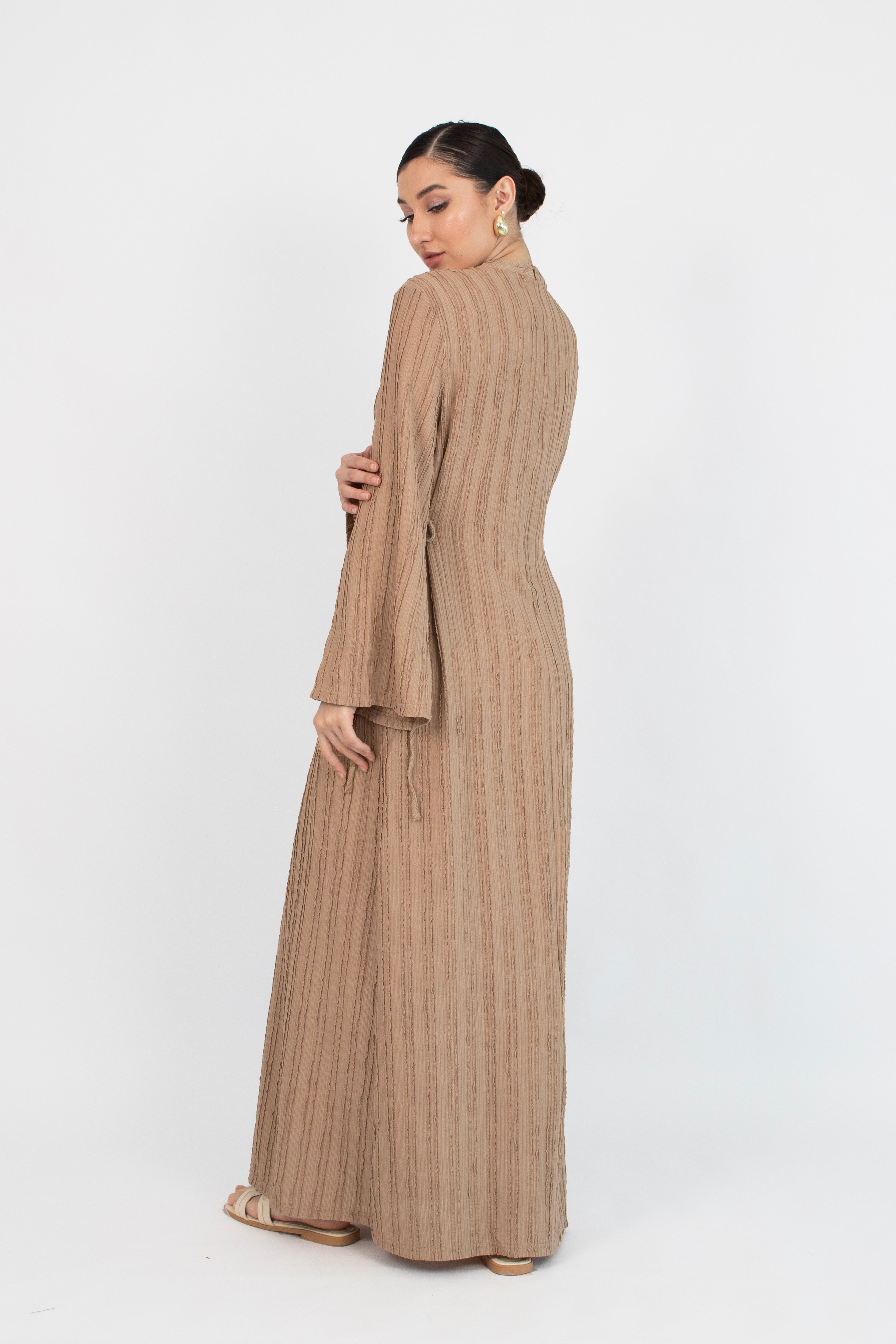 Colour description: Latte The model is shown from behind in a bow dress.