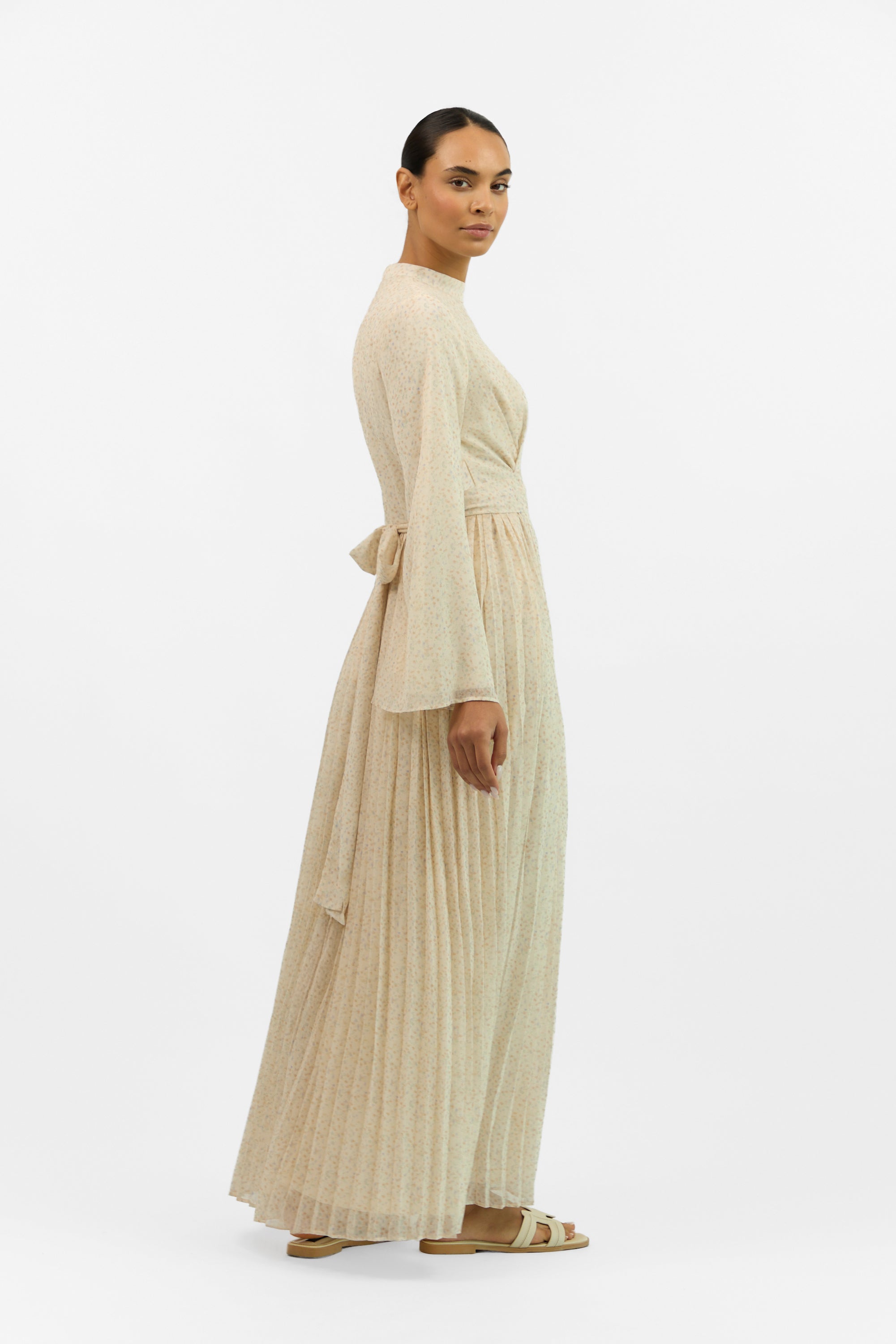 Side profile of the FARES Printed Tie Dress with Pleats, showing the flowy pleats and soft tie neckline of the printed dress.