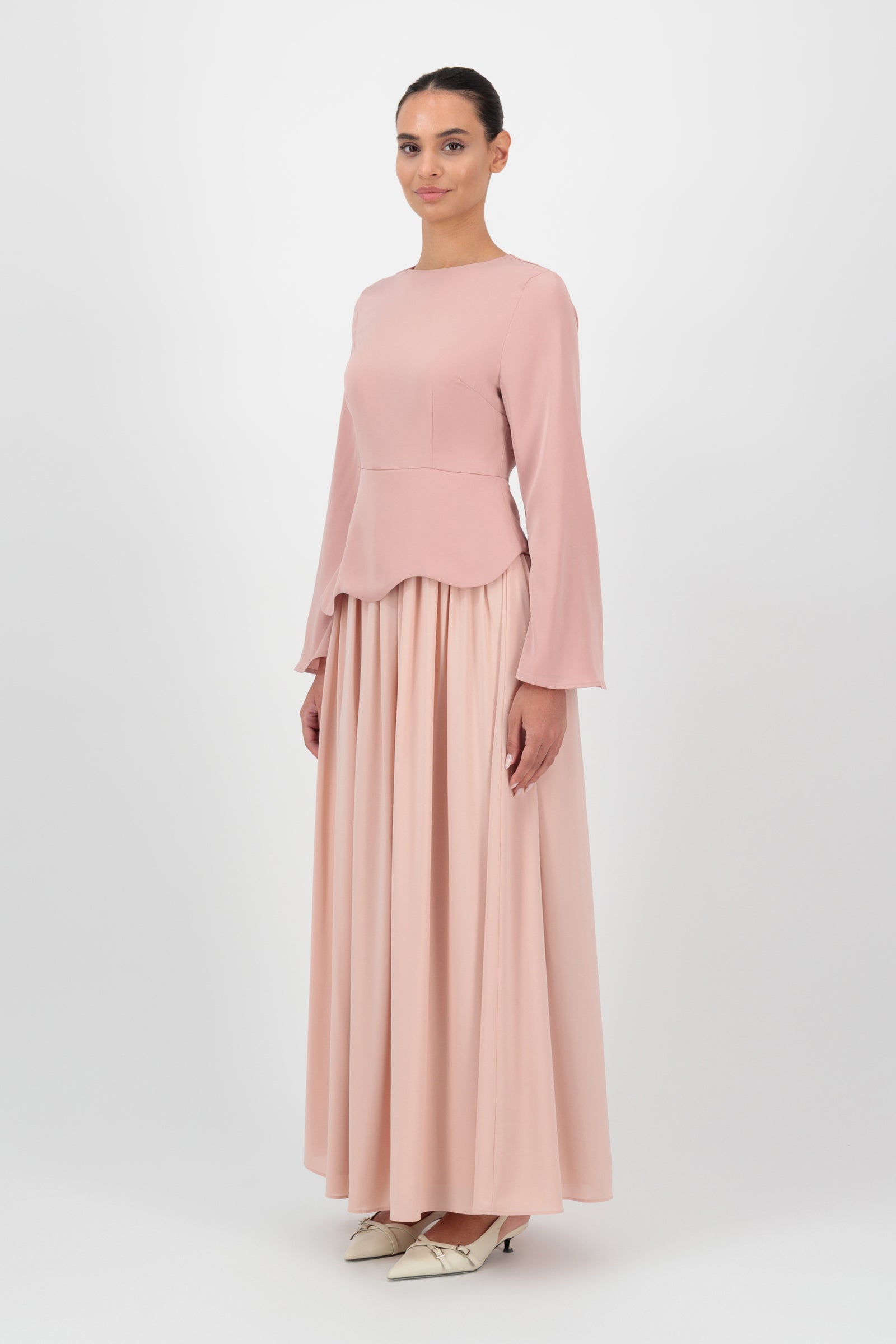 Side view of the FARES Two Tone Scalloped Peplum Dress in Farawla highlights the structured peplum silhouette and fluid movement that define this refined peplum dress.